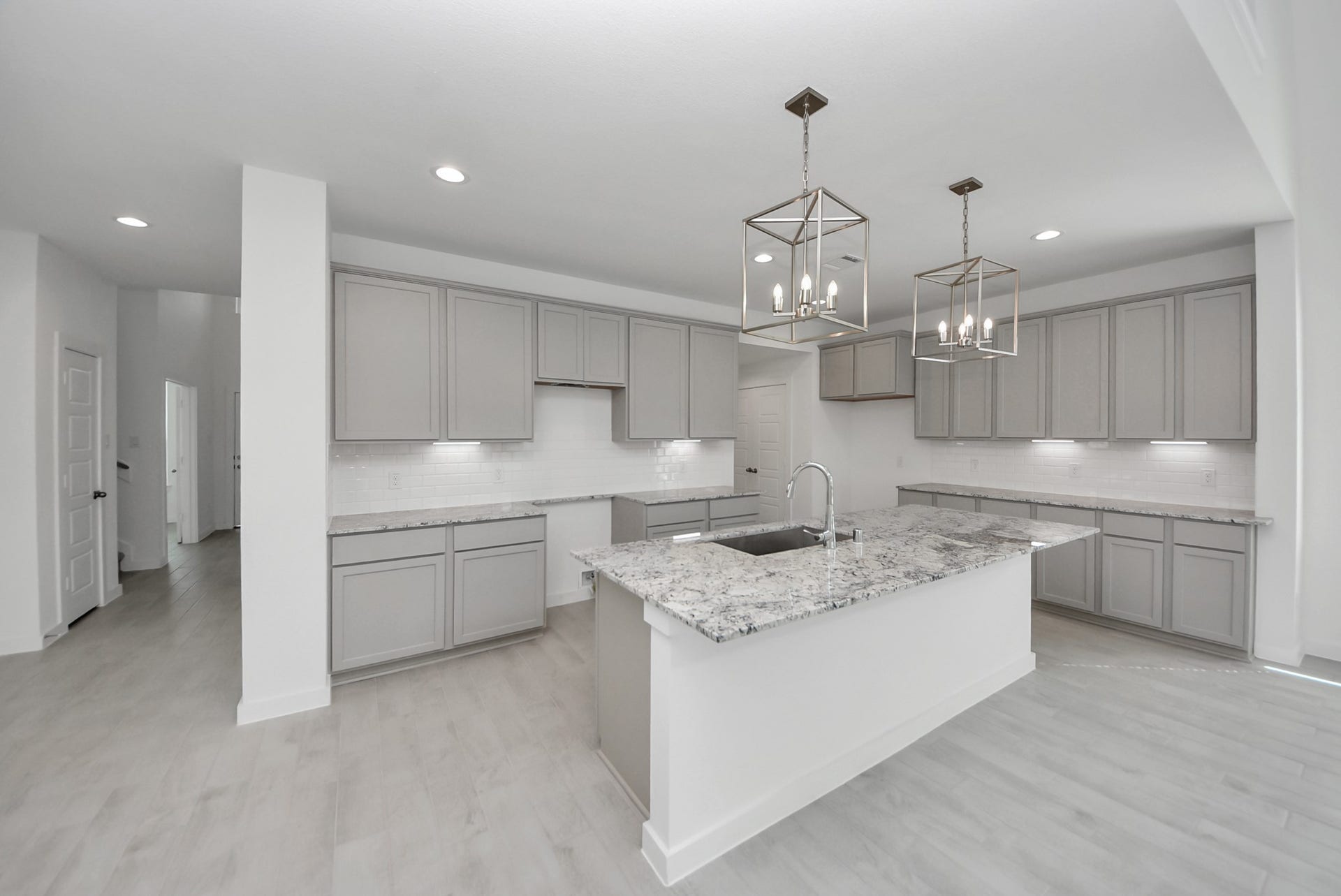 This kitchen is by far any chefs dream! This spacious kitchen features high ceilings, stained wood cabinets, granite countertop, SS appliances, modern tile backsplash, recessed lighting, extended counter space, granite kitchen island with double sink, and space for breakfast bar, and a walk-in pantry all overlooking your huge family room.