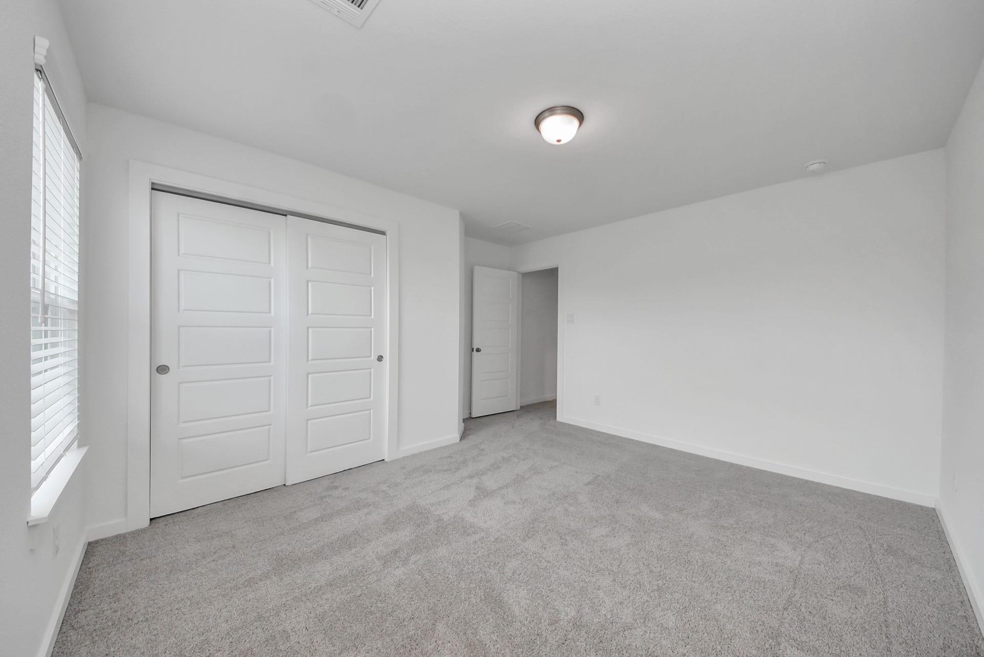 Generously sized secondary bedrooms featuring spacious closets, soft and inviting carpeting underfoot, large windows allowing plenty of natural light, and the added touch of privacy blinds for your personal retreat.