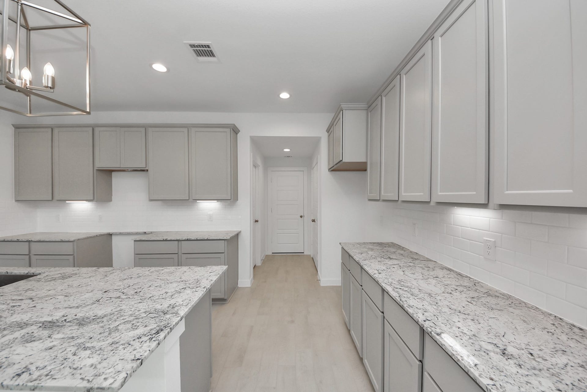 Step into a dream realized with this generously spacious kitchen! A massive granite island takes center stage, complemented by high ceilings and soft-close cabinets. The granite countertops, stainless steel appliances, sleek tile backsplash, and recessed lighting complete the elegant design.
