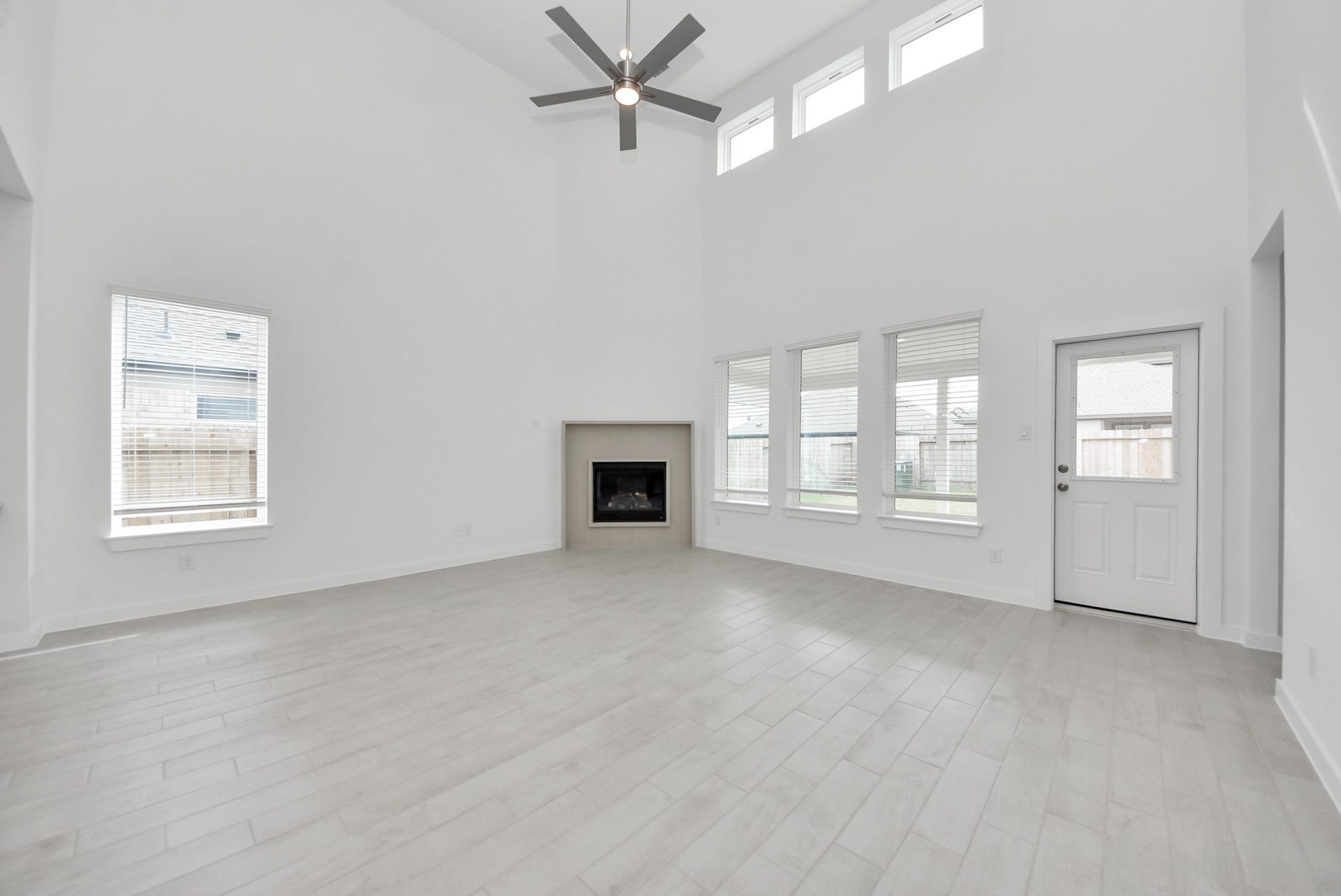Relax and unwind in this inviting family room, illuminated by abundant natural light streaming in through tall windows, complemented by high ceilings and stunning flooring. Stay comfortable year-round with the gentle breeze from the ceiling fan, creating the perfect atmosphere for family gatherings.