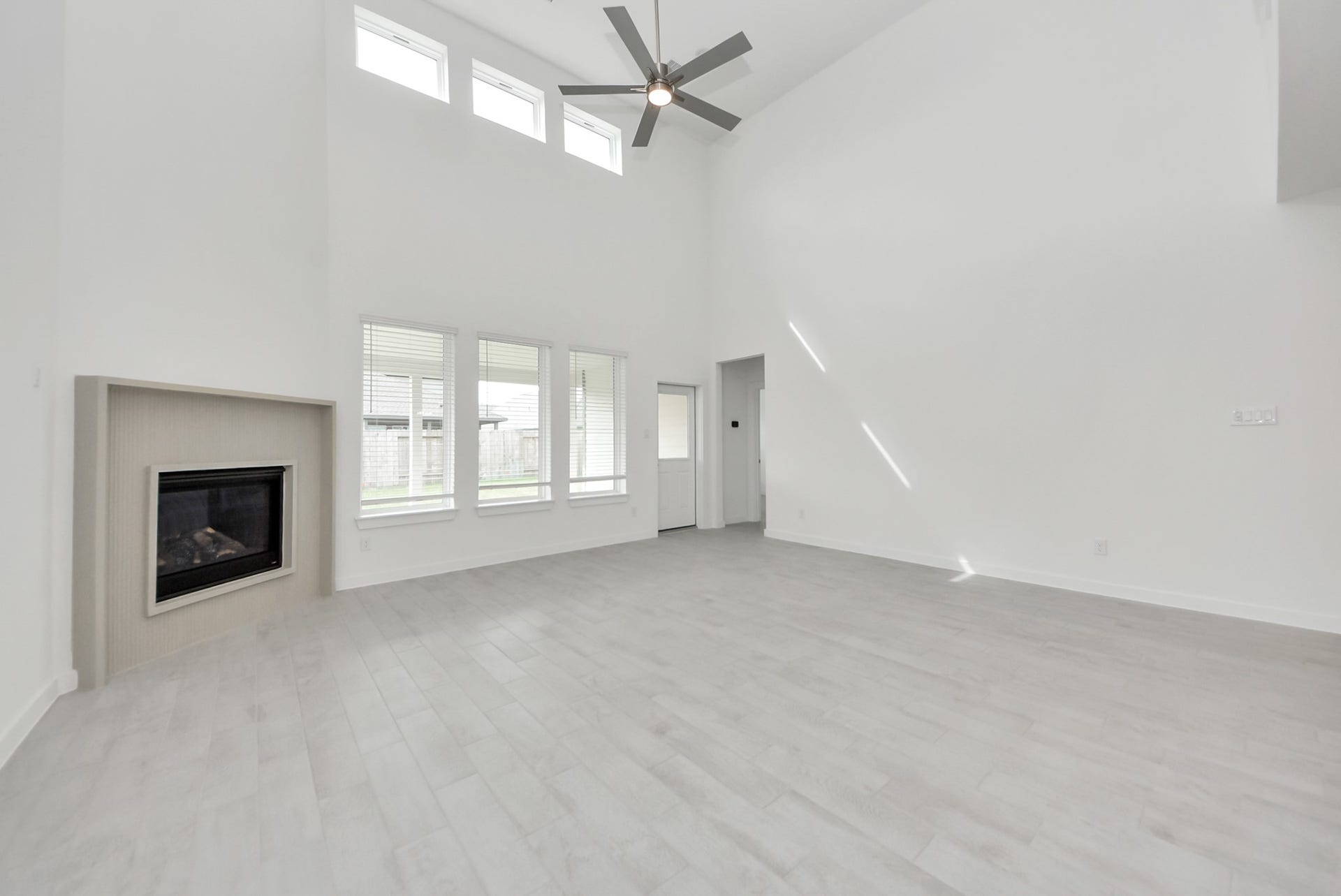 Gather the family and guests together in your lovely living room! Featuring soaring high ceilings, recessed lighting, ceiling fan, custom paint, gorgeous floors, and large windows that provide plenty of natural lighting throughout the day.