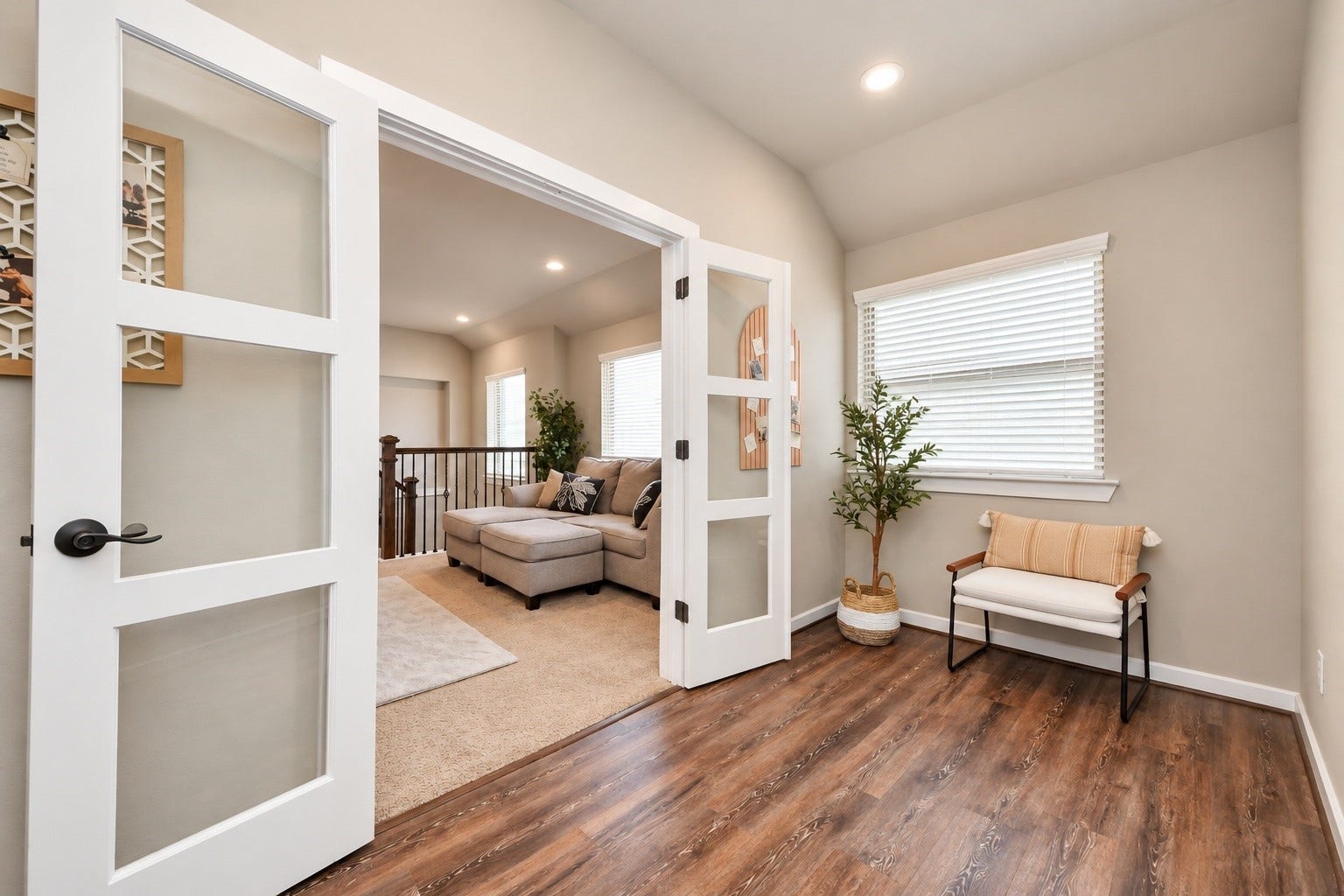 Dedicated home office featuring glass French doors, wood-look flooring, and abundant natural light, ideal for working from home.