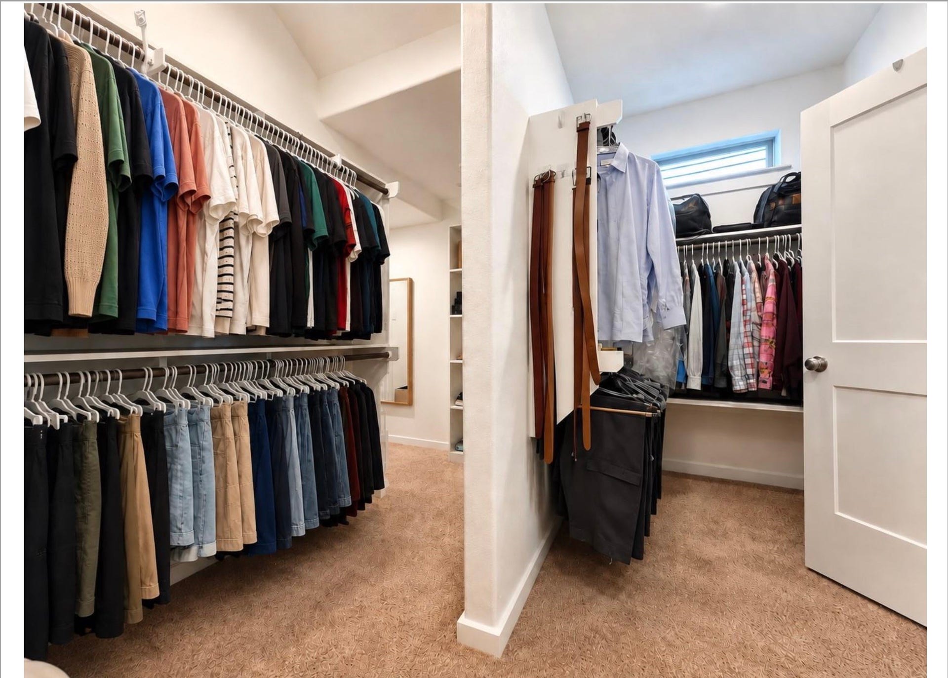 Expansive primary walk-in closet featuring extensive built-in shelving, multiple hanging areas, and plenty of space for organized storage.