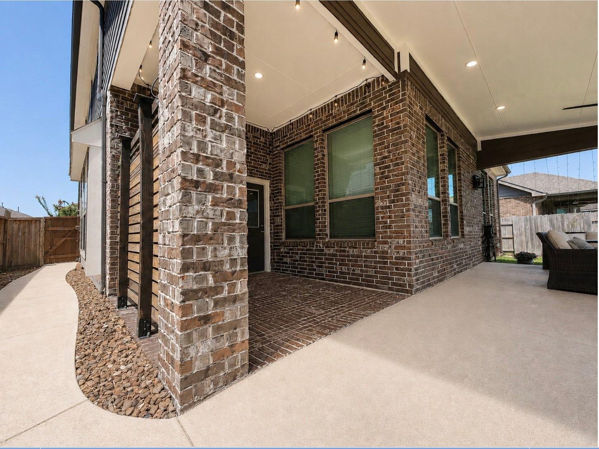 Attractive brick and stone exterior with an attached two-car garage, covered patio access, and a spacious driveway.