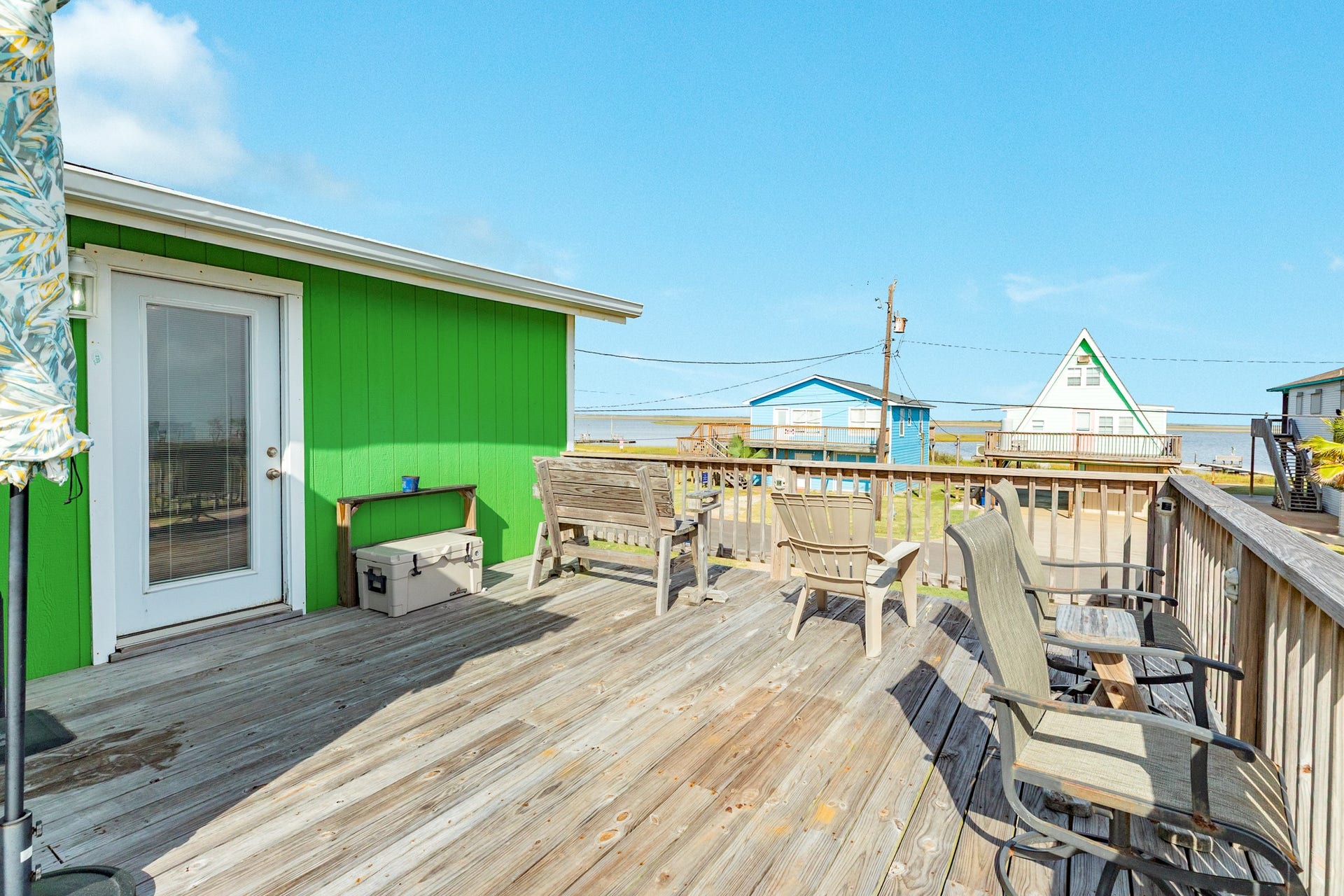 Spacious wood deck offers plenty of room for outdoor seating while capturing views toward the nearby bay.