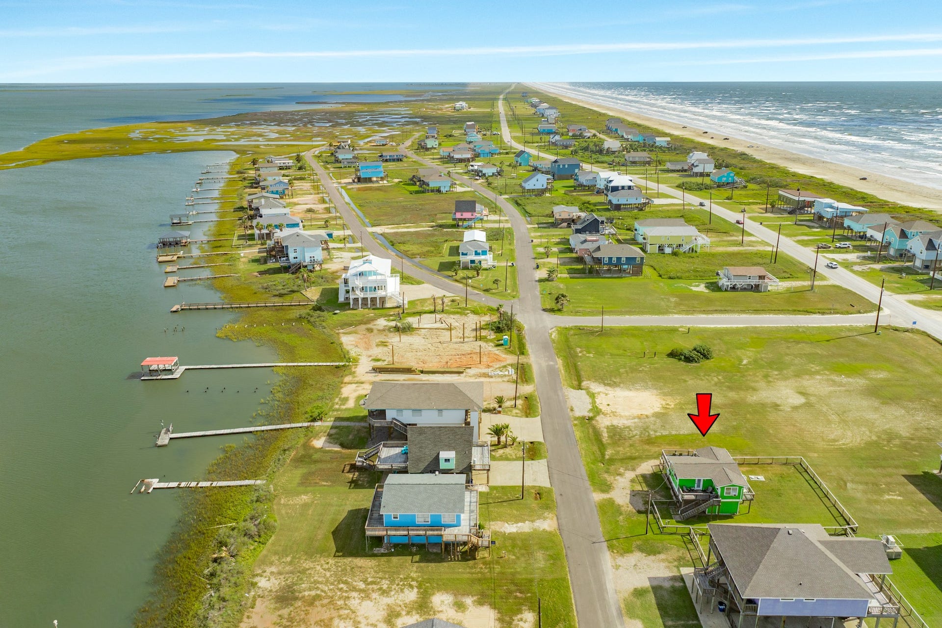 Sweeping aerial view illustrates the homes setting between expansive bay waters and the Gulf shoreline.