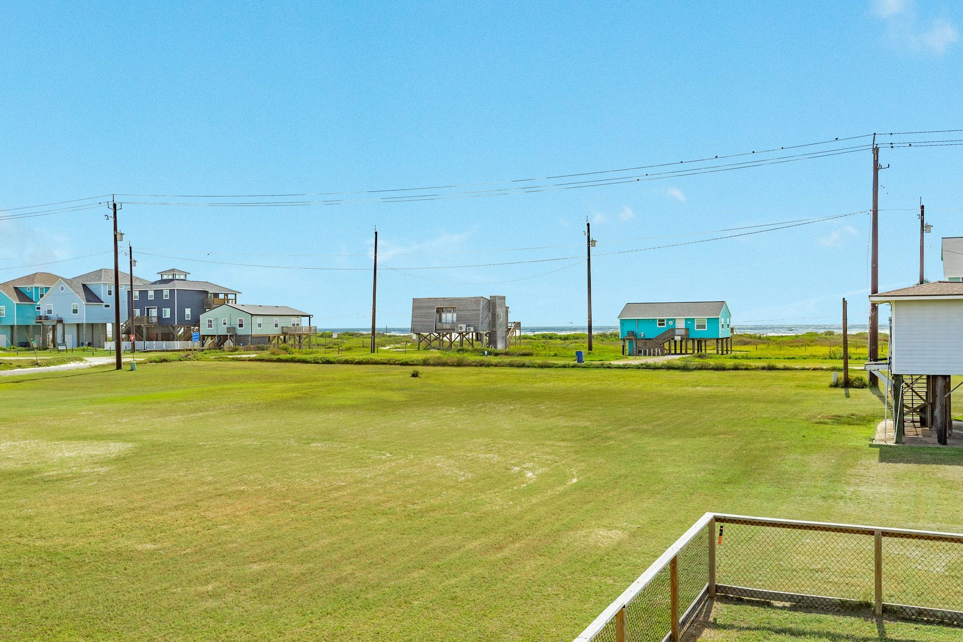 Wide-open view across the neighboring green space toward the Gulf highlights the homes coastal location.