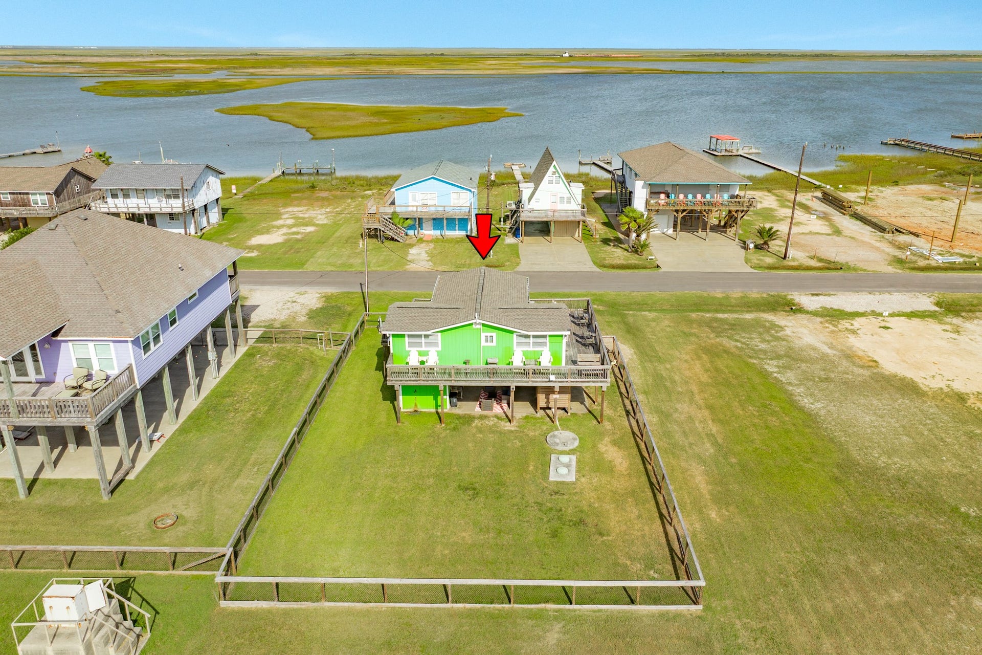 Elevated view places the property within its coastal setting, with broad water and marsh views just across the roadway.