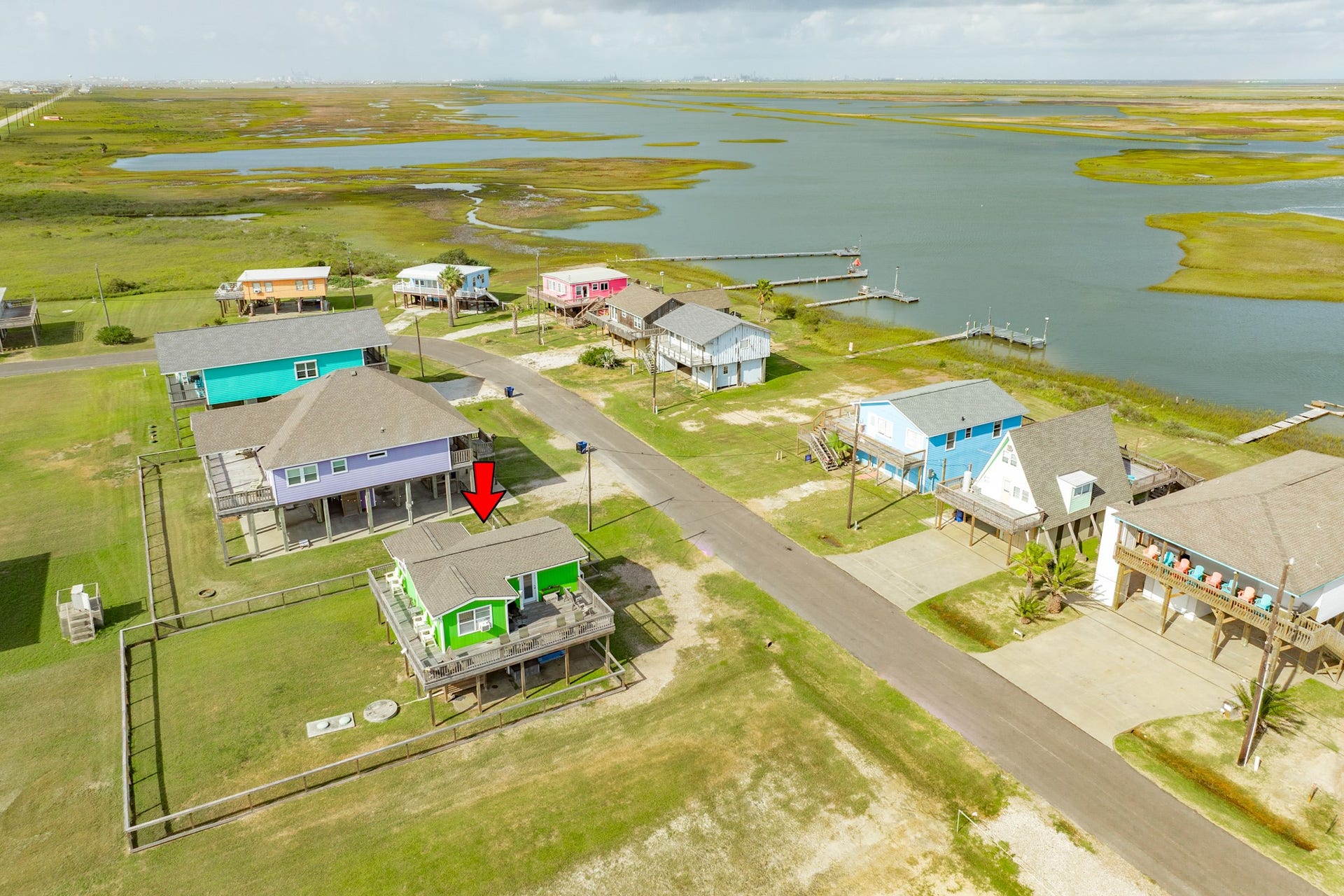 The property is identified within a scenic coastal community surrounded by waterways, marshland, and nearby docks.