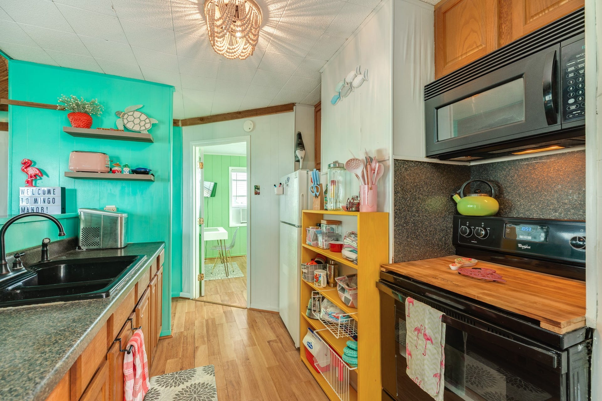 Galley-style kitchen includes ample counter space, wood cabinetry, a refrigerator, range, and built-in microwave.