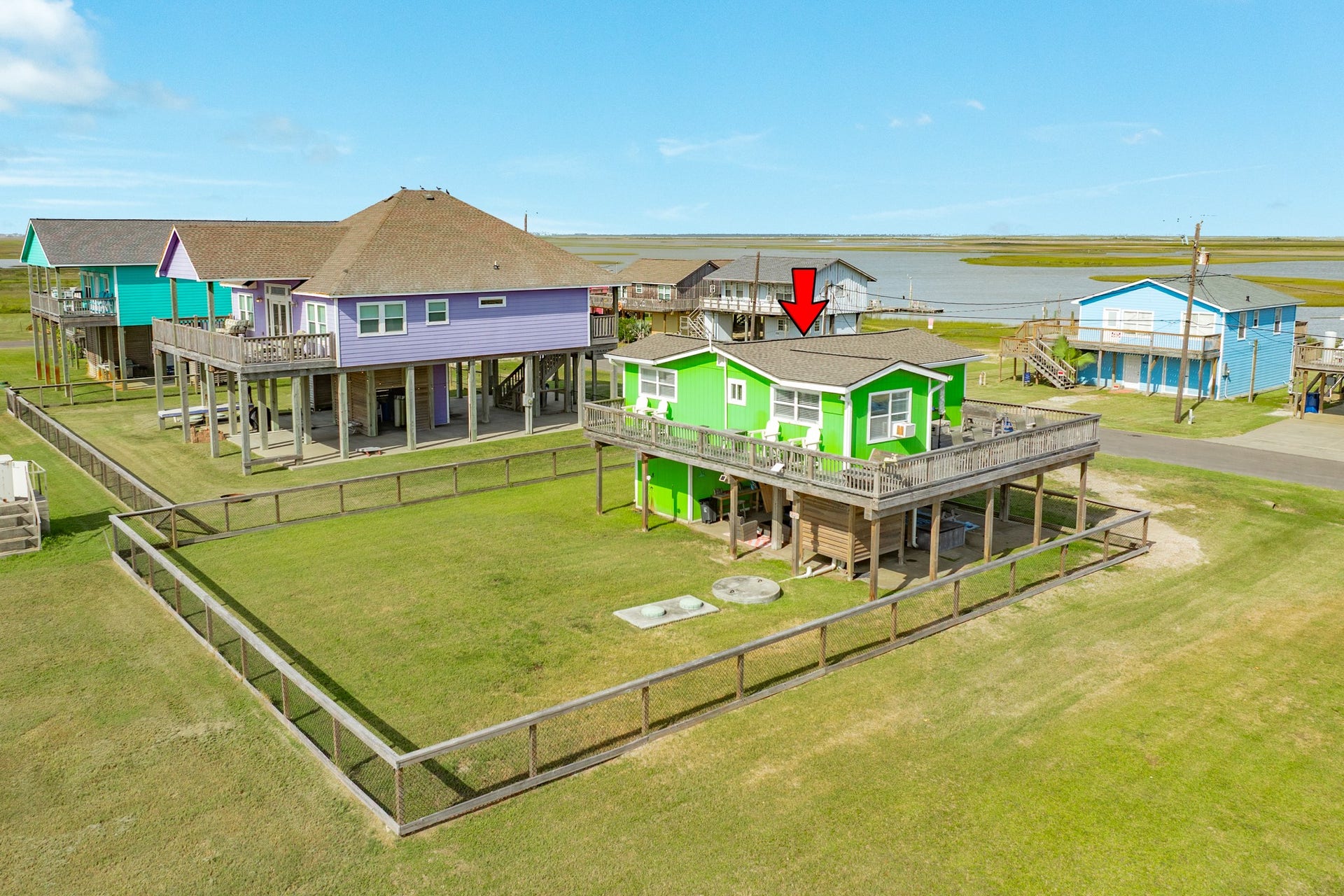 Aerial perspective showcases the homes sizable fenced yard and close proximity to expansive coastal waterways.