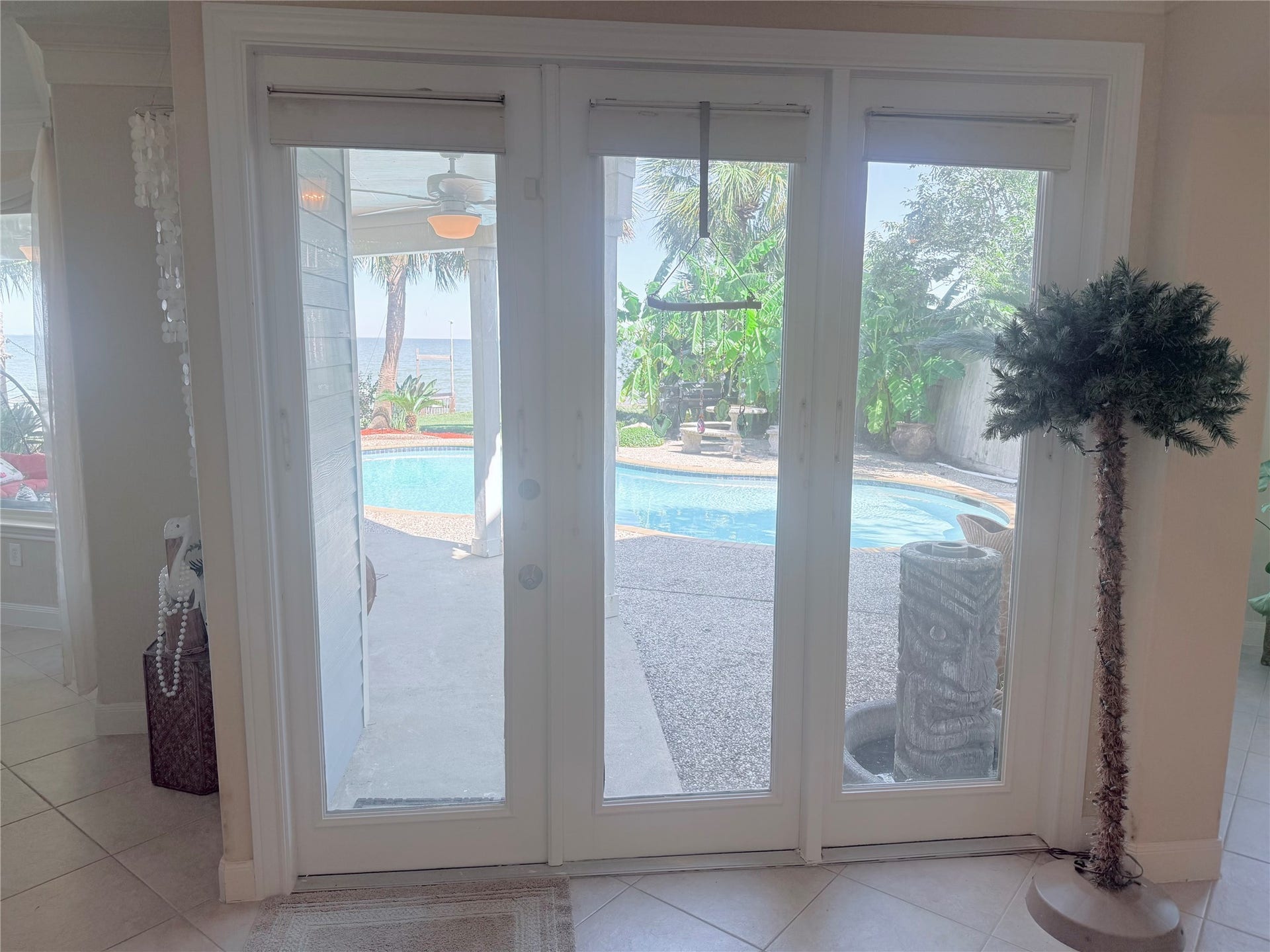 4715 W Bayshore Drive, Bacliff, TX 77518 Glass doors overlooking the pool, garden and water view.