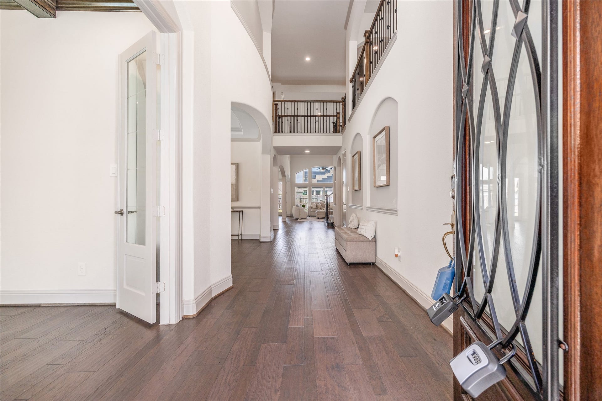 13506 COLUMBIA KEY Drive, Tomball, TX 77377 From the front door, a long, open sightline draws you toward the living space, with rich wood floors carrying the view throughout.