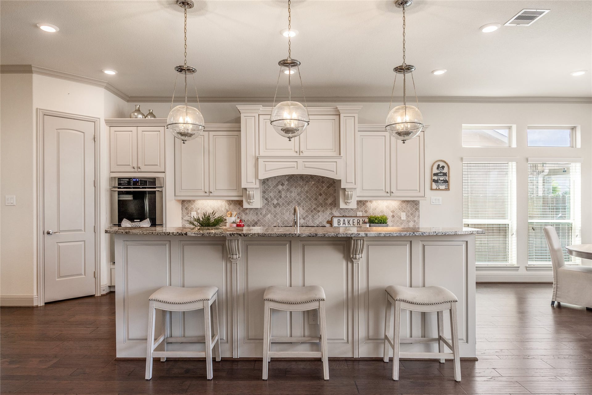 13506 COLUMBIA KEY Drive, Tomball, TX 77377 Chefs kiss: statement pendant lights, detailed cabinetry, and granite countertops with a raised breakfast bar made for gathering.