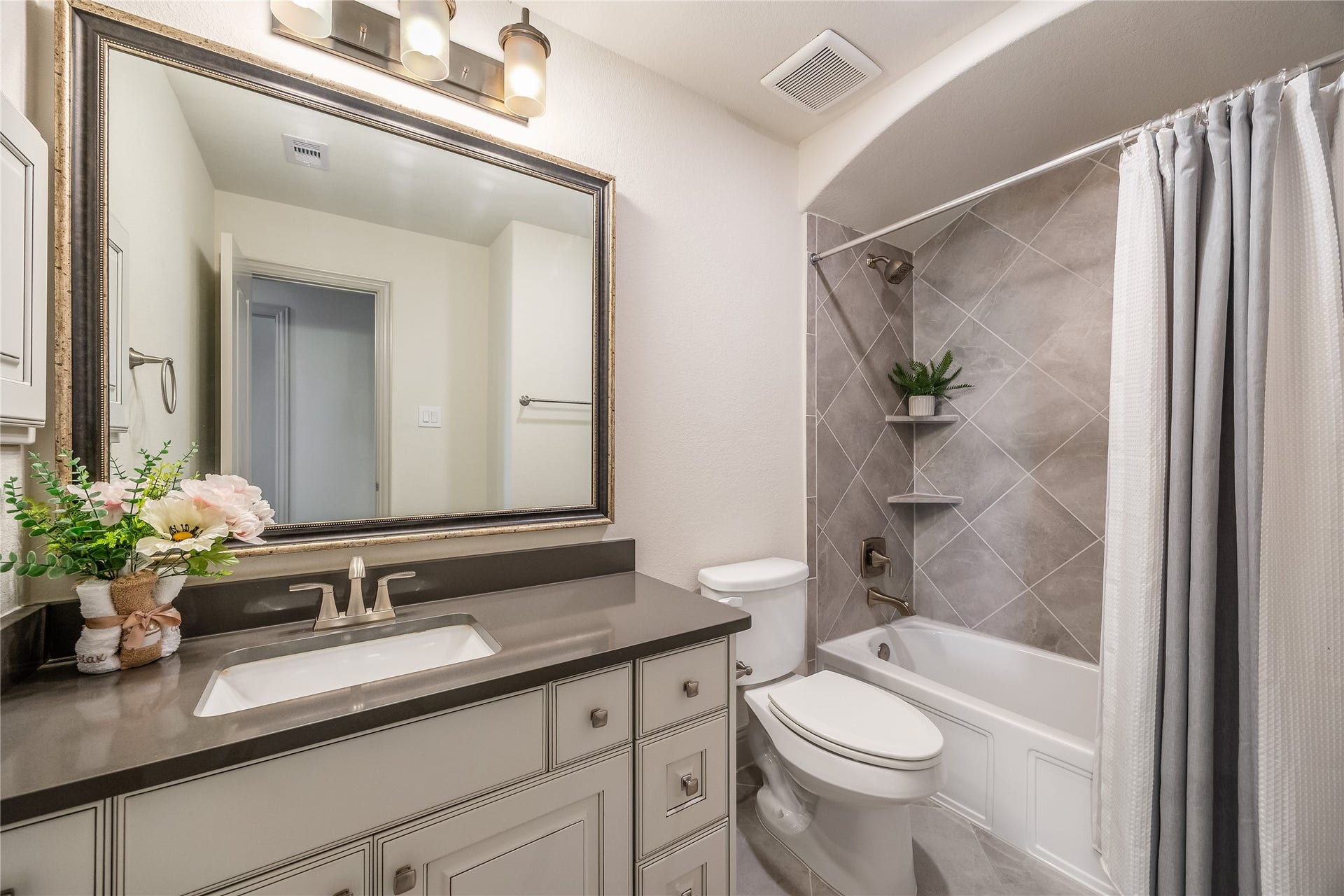 13506 COLUMBIA KEY Drive, Tomball, TX 77377 The upstairs bath serves both bedrooms and visiting guests, with a spacious vanity and tiled tub surround.