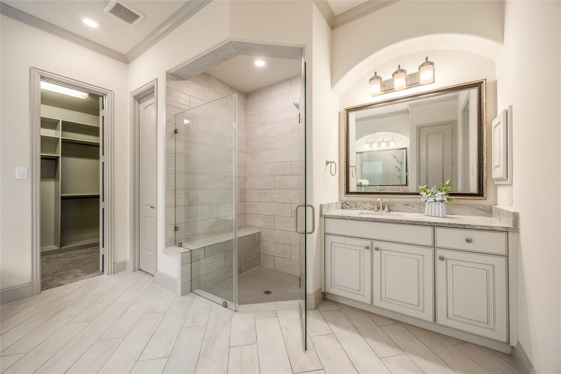 13506 COLUMBIA KEY Drive, Tomball, TX 77377 A closer look at the primary bath: a frameless glass shower with a built-in bench, an elegant vanity, and direct access to the walk-in closet.