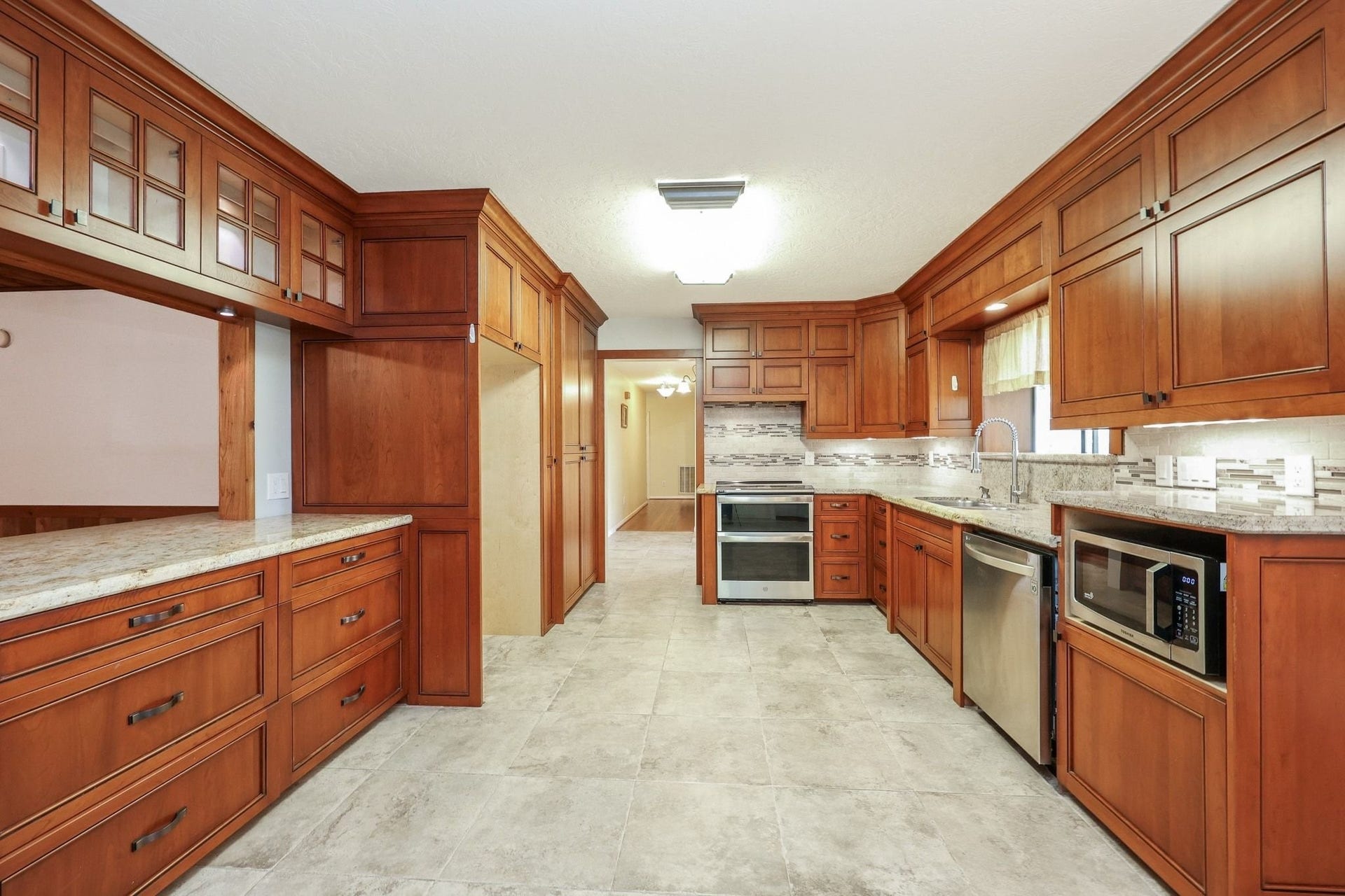 22107 Rosewood Trail, Tomball, TX 77377 Kitchen with Custom Cabinets, a Double Electric Oven, Pantry Storage, Microwave Shelf has Beautiful Views of the Neighborhood Lake