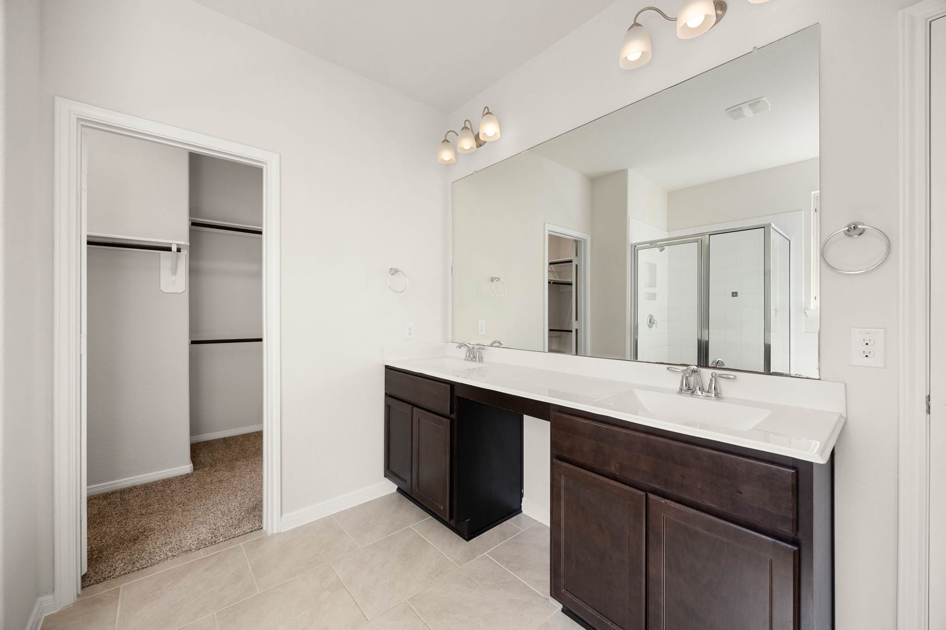 23643 Balzano Court, Katy, TX 77493 Luxurious primary bathroom retreat featuring an expansive double vanity, rich espresso cabinetry, and seamless access to a spacious walk-in closet.