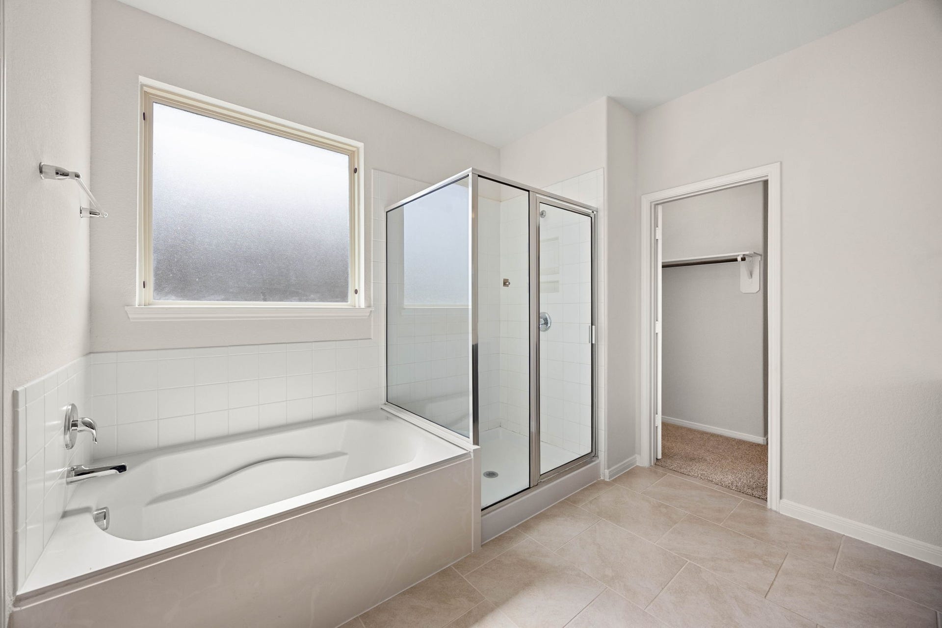 23643 Balzano Court, Katy, TX 77493 Spa-like primary bathroom oasis boasting a deep soaking tub, a separate glass-enclosed shower, and bright, private natural light.