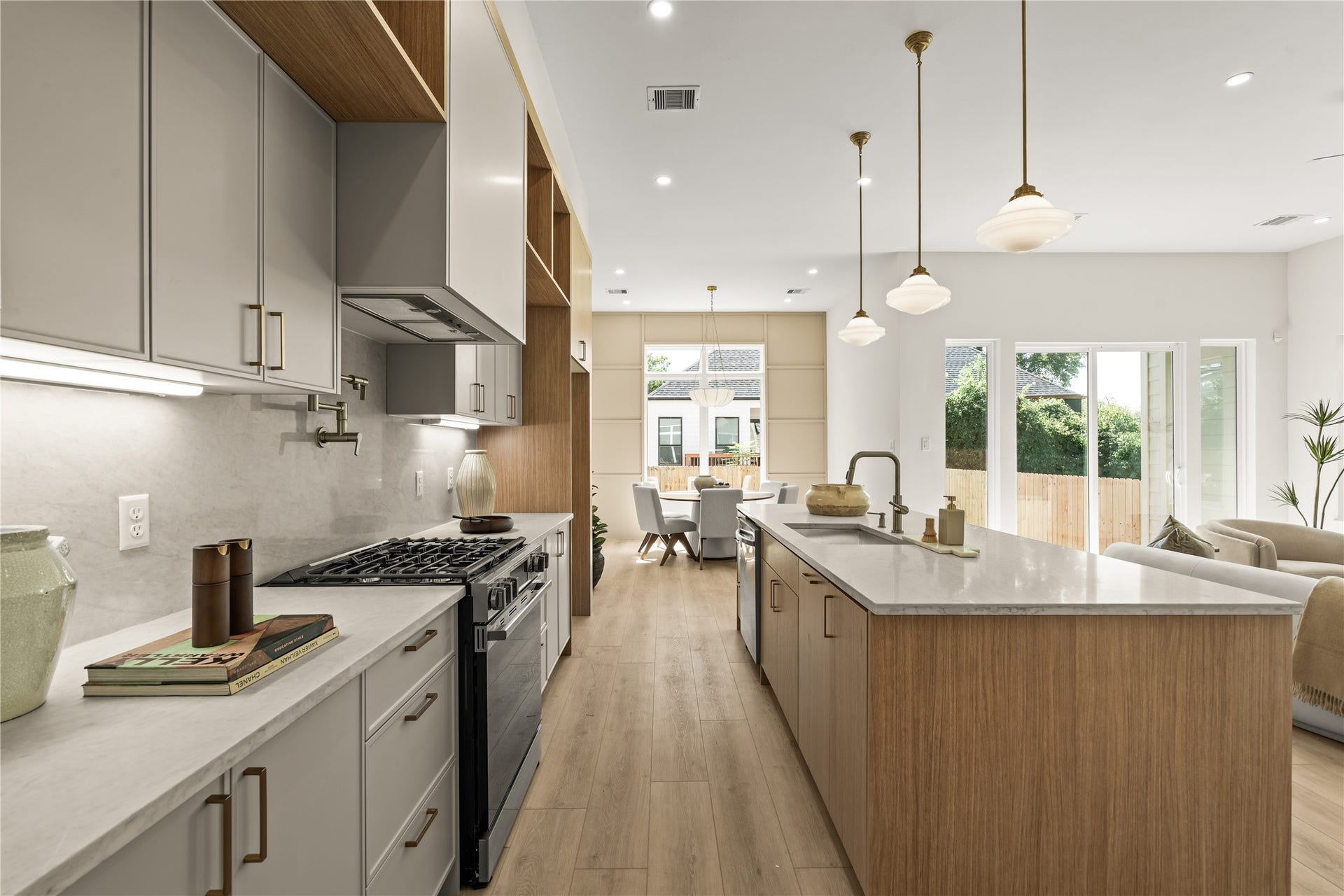 Gas range, quartz counters, and a clear look to the backyard from the stove. Cook with the sliders open and the patio in view.
