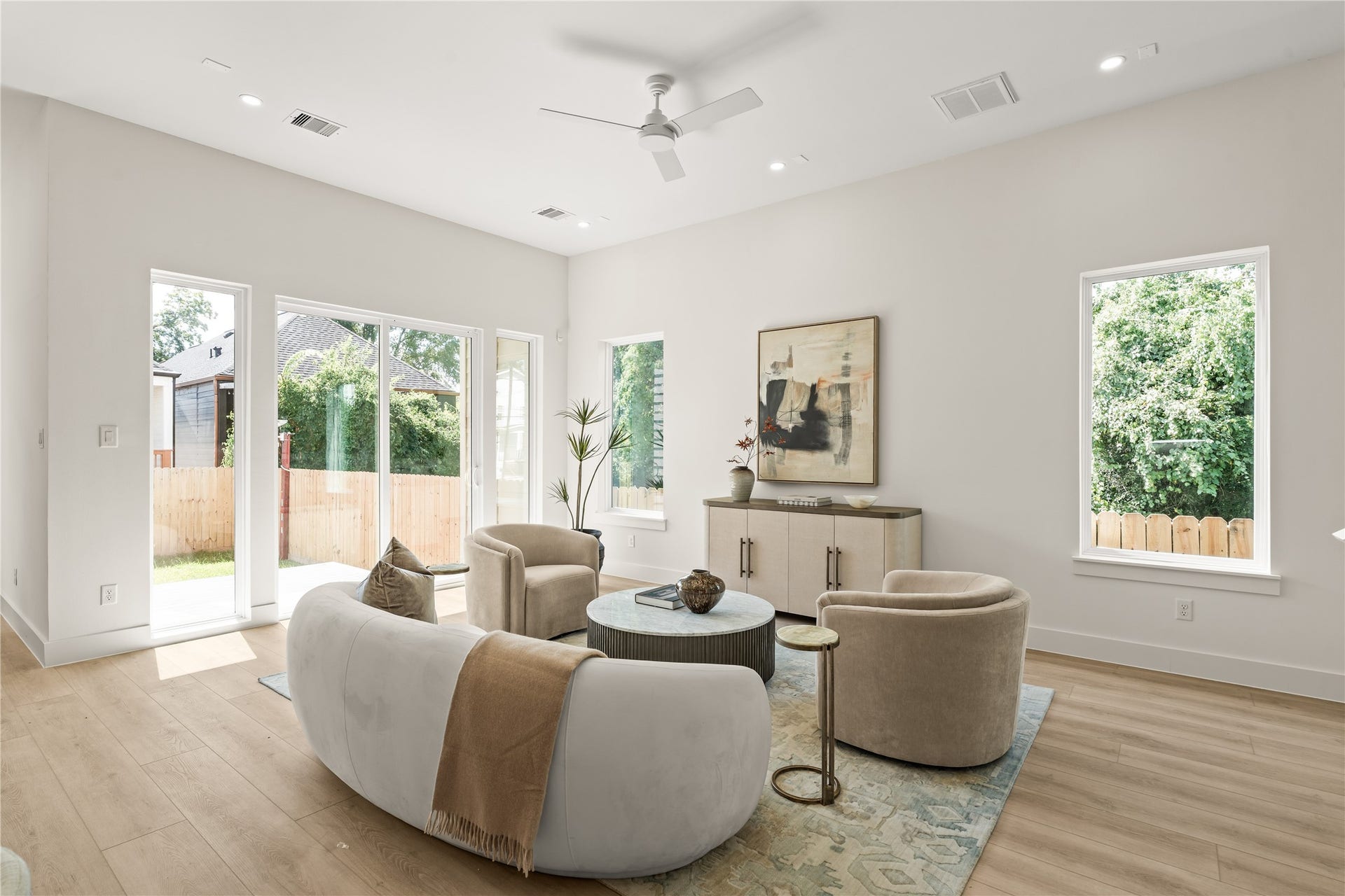 Light from both ends of the living room, windows on the side wall, sliders on the back. The layout does the work, so the furniture is just there to prove it.