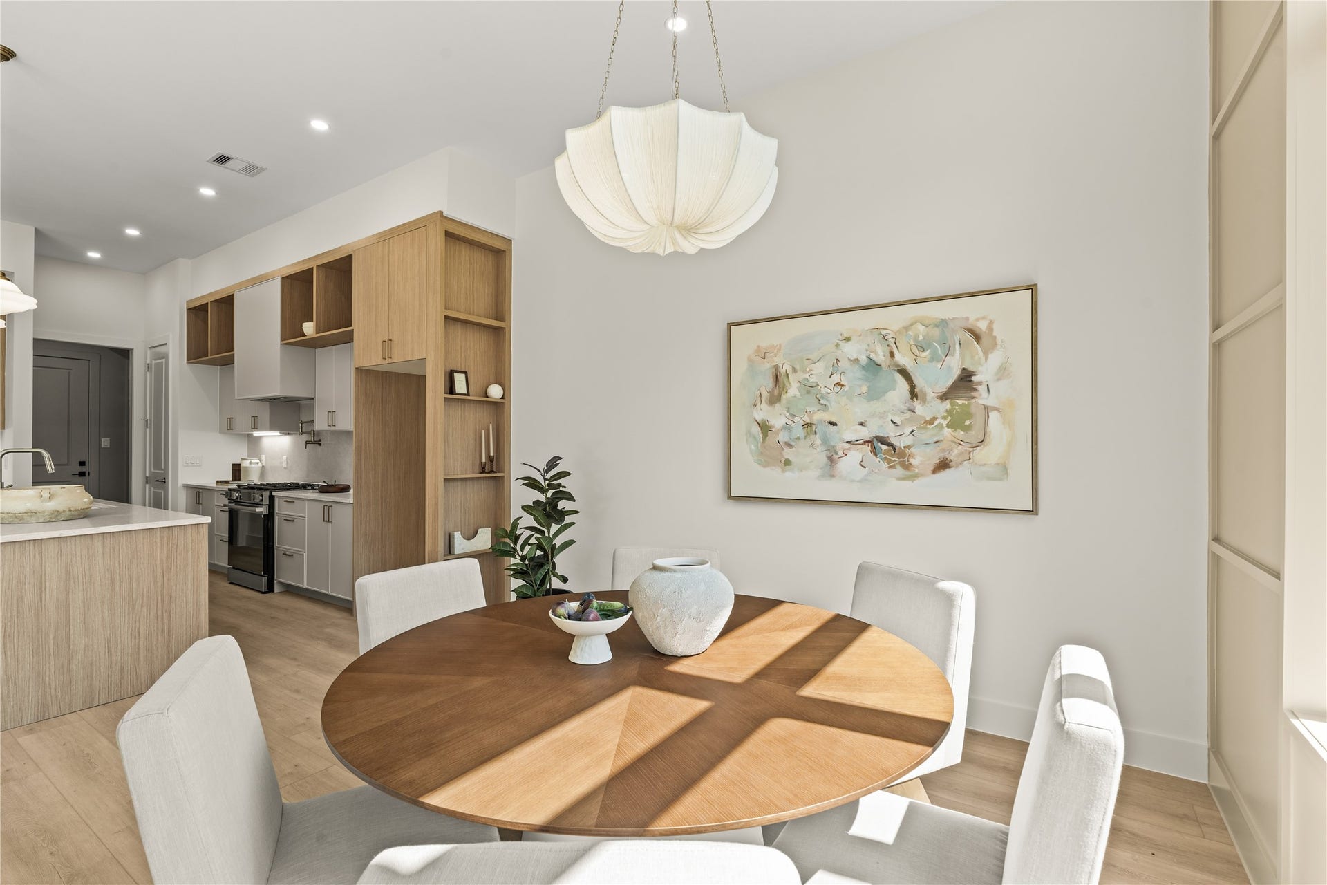 Dining to kitchen in a few steps. The pendant, the panel wall, and the island all line up from here.