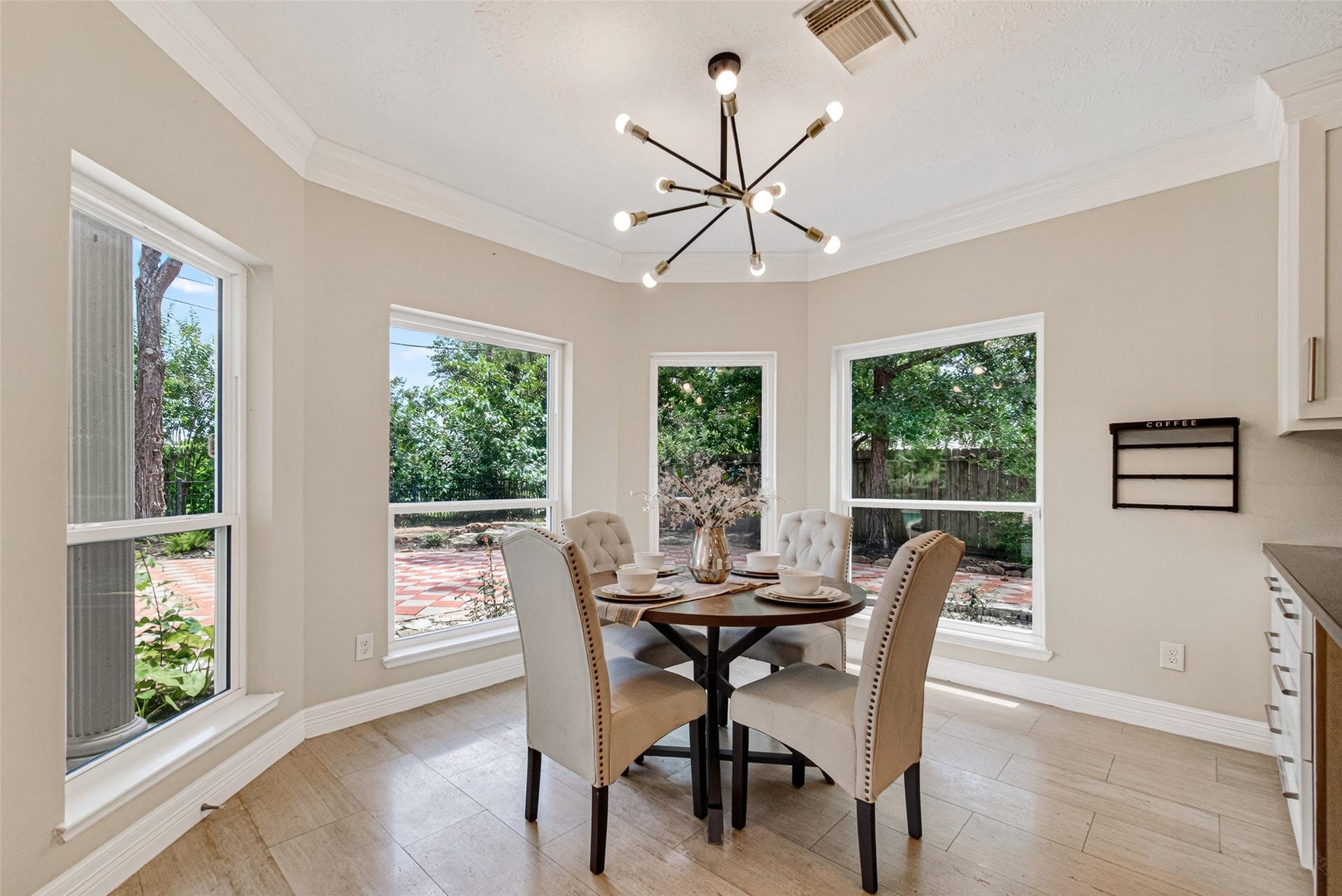 Bright and inviting breakfast nook with large windows overlooking a lush garden.