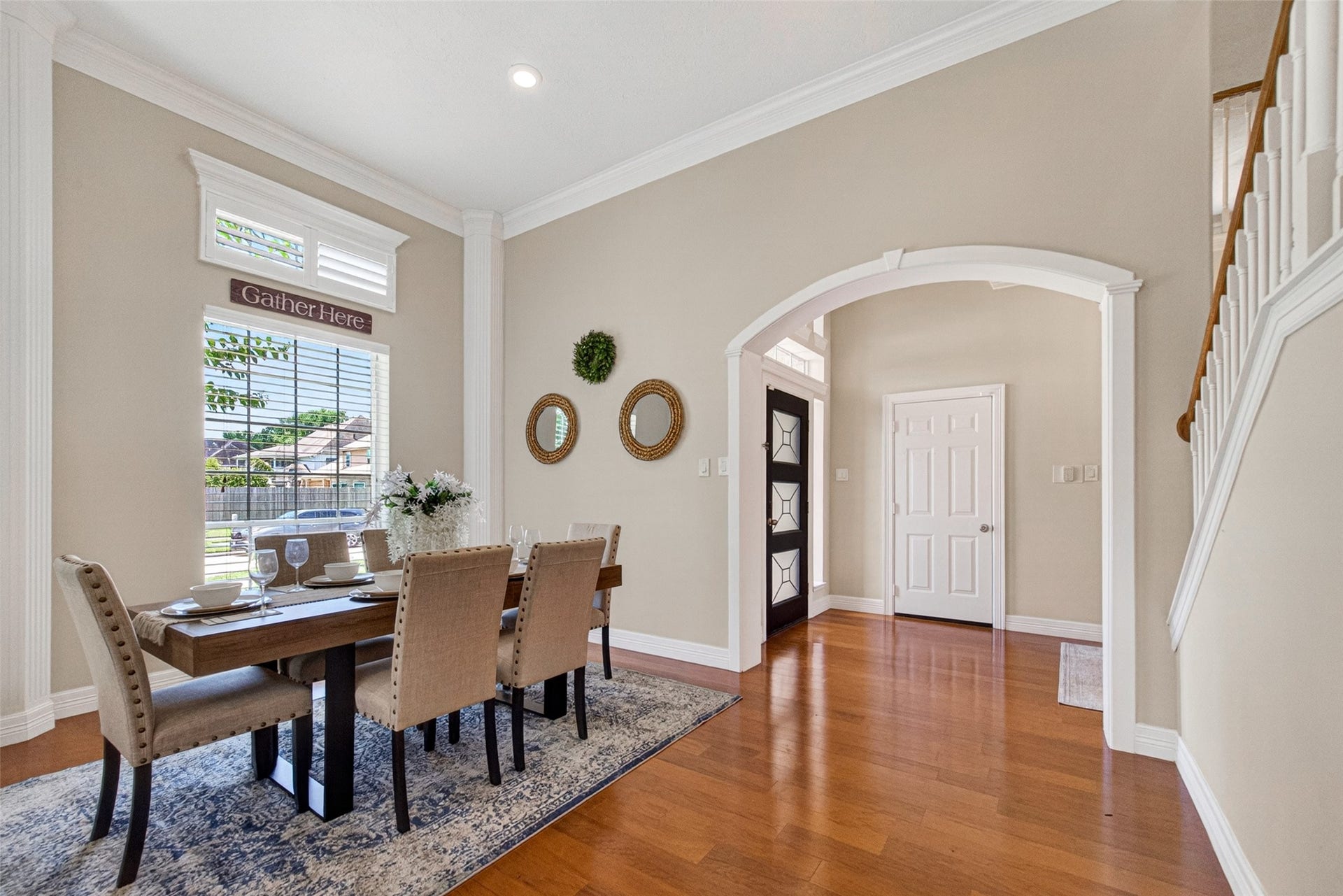 Elegant dining room featuring high ceilings, large windows for natural light, and a stylish archway leading to the hallway.