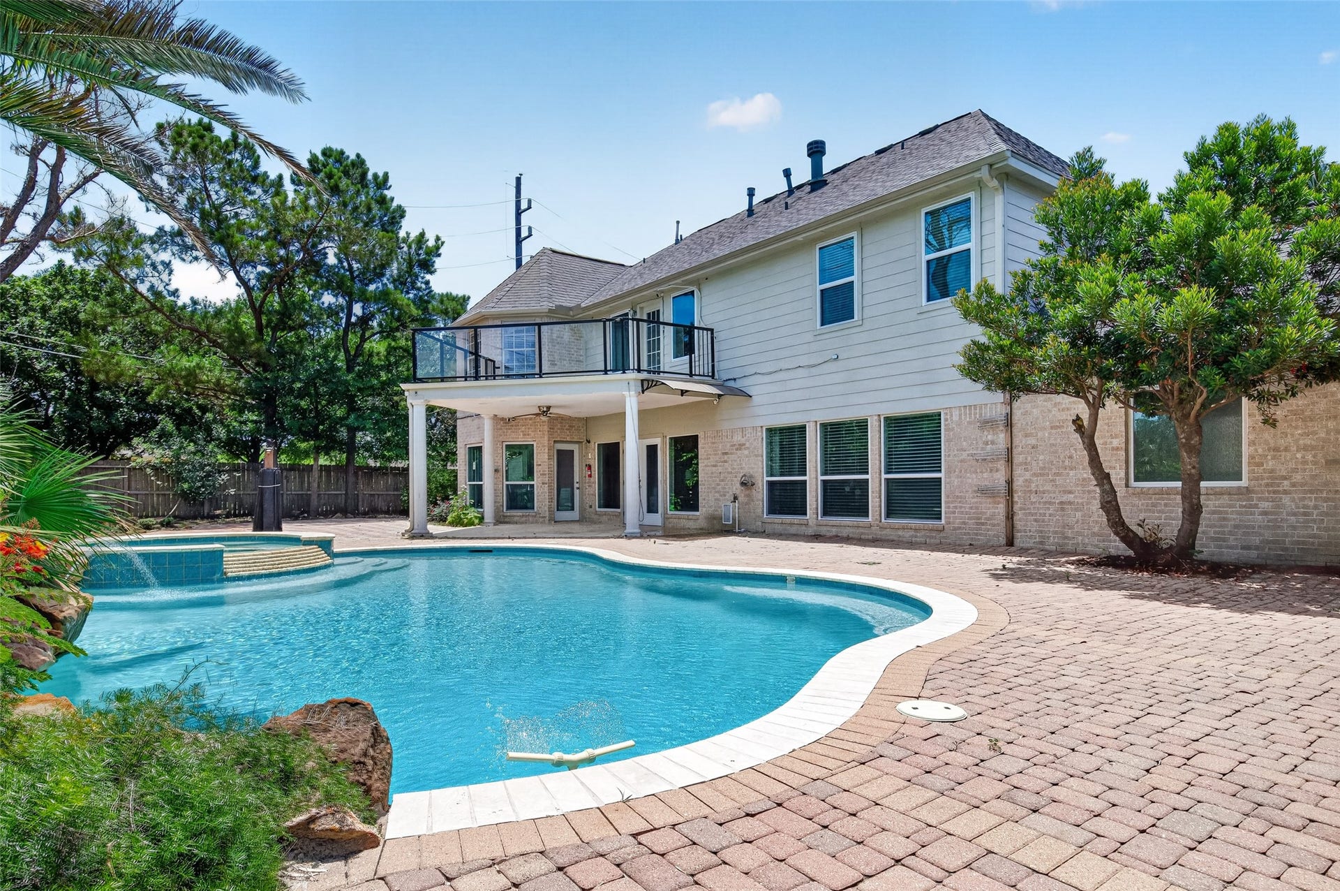 Stunning backyard oasis featuring a sparkling pool, elegant patio, and lush landscaping, perfect for entertaining and relaxation.