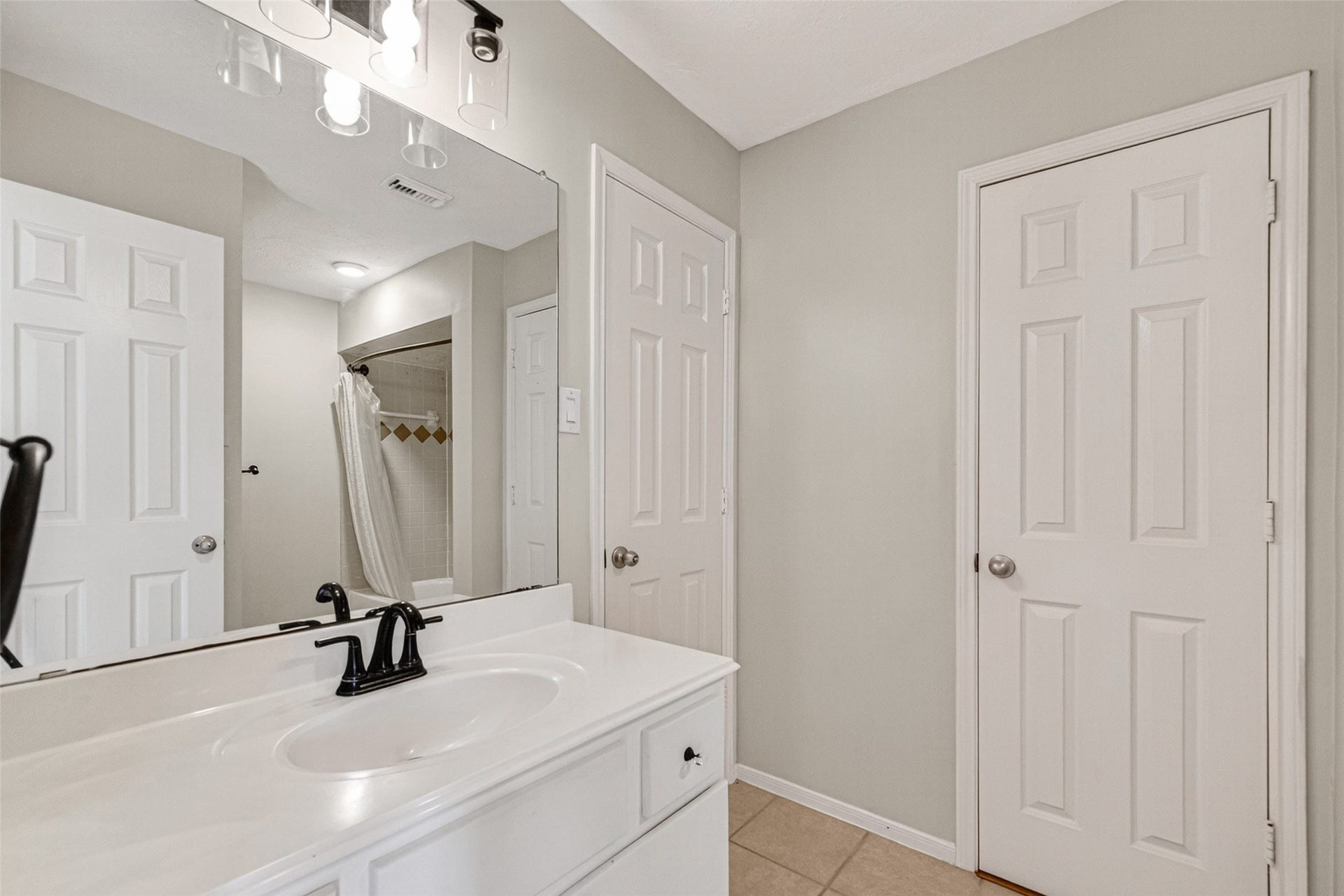 Upstairs bathroom #2 offers a sleek vanity with modern fixtures, ample storage, and a convenient shower-tub combination for ultimate comfort and style.