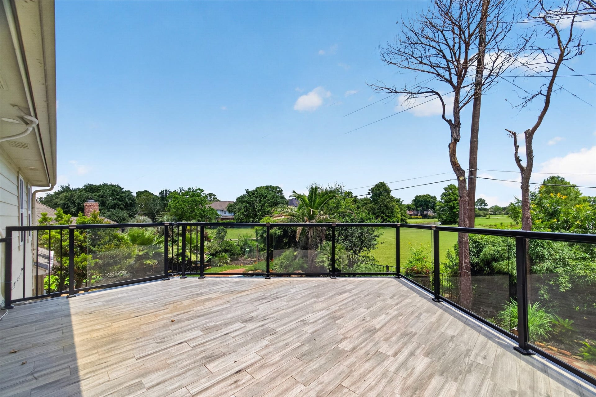 Spacious balcony with sleek glass railing offers stunning views of the golf court Ideal for relaxing or entertaining outdoors.