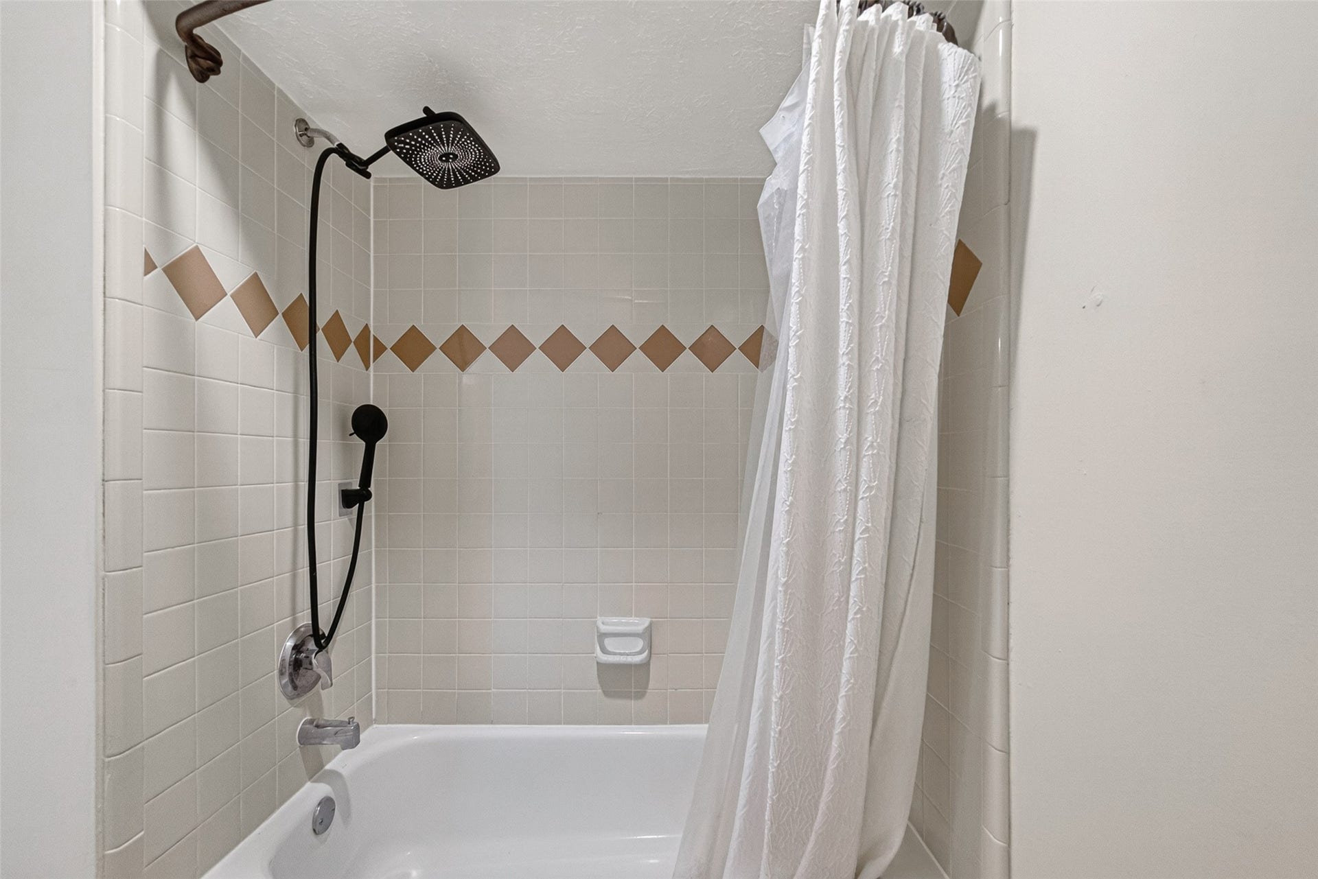 Modern bathroom features a stylish shower with a rain showerhead and elegant tile accents, creating a relaxing oasis.