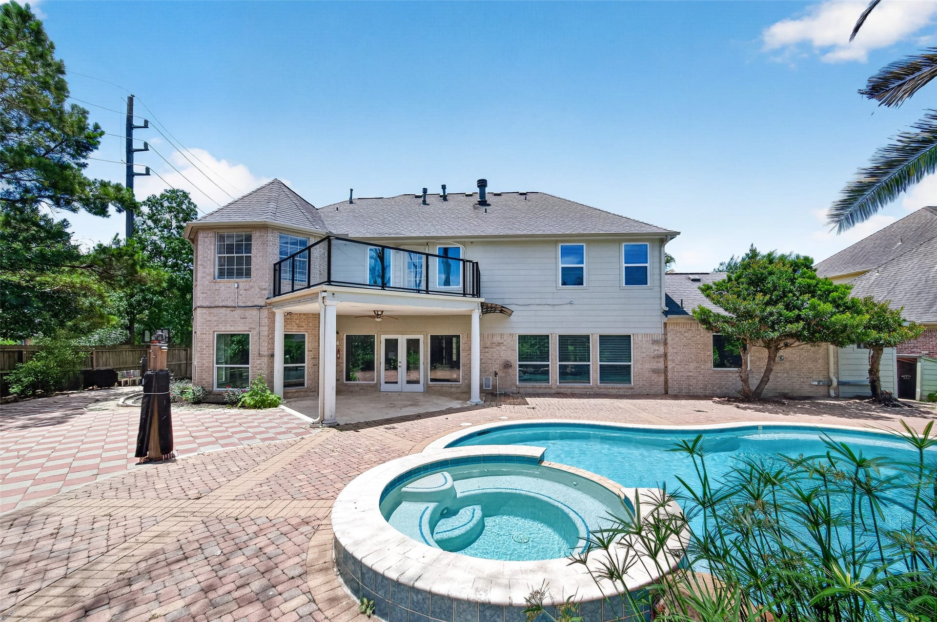 Spacious two-story home with a large backyard featuring a sparkling pool and spa, perfect for entertaining and relaxation.