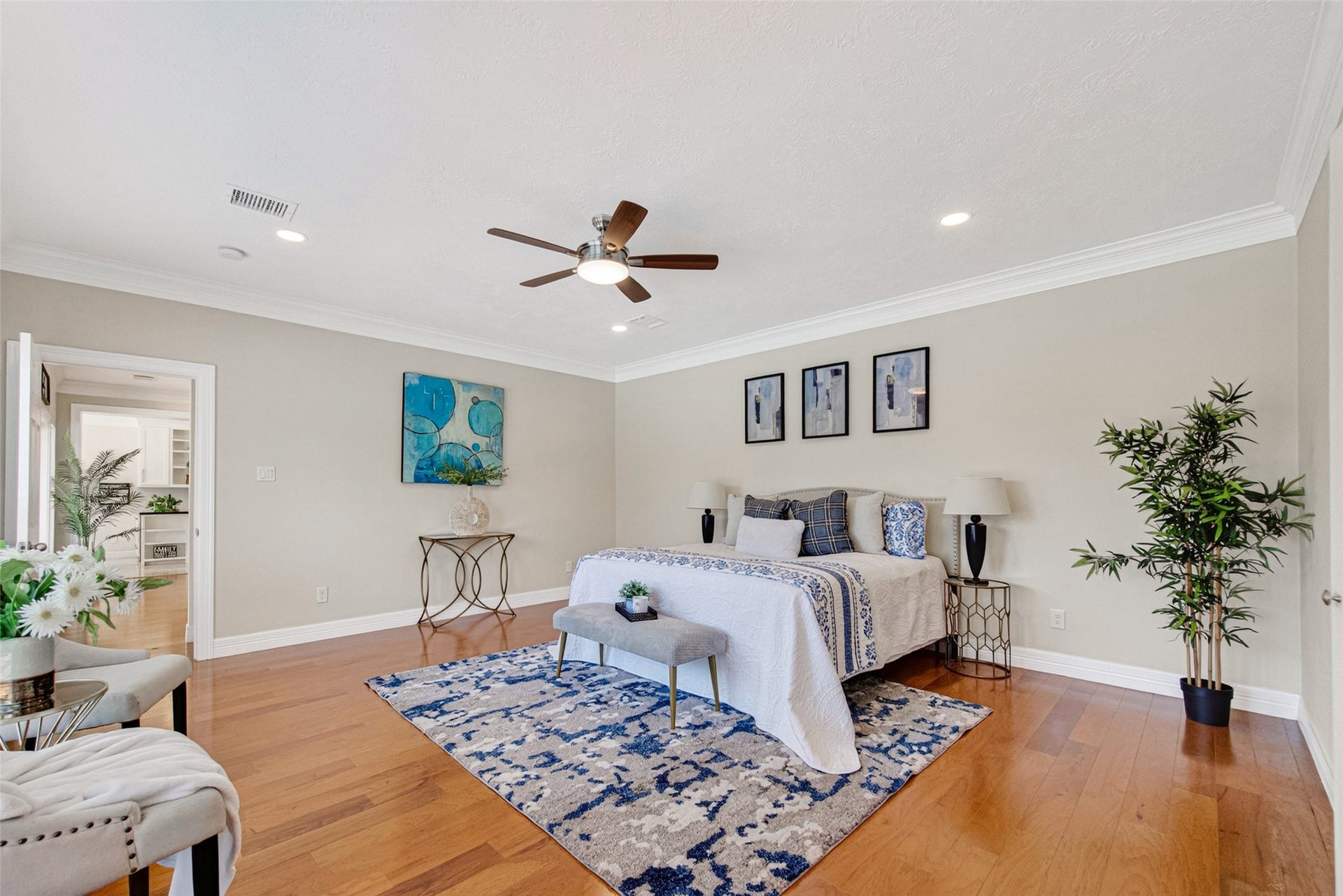 Spacious and inviting the primary bedroom with warm wood floors.