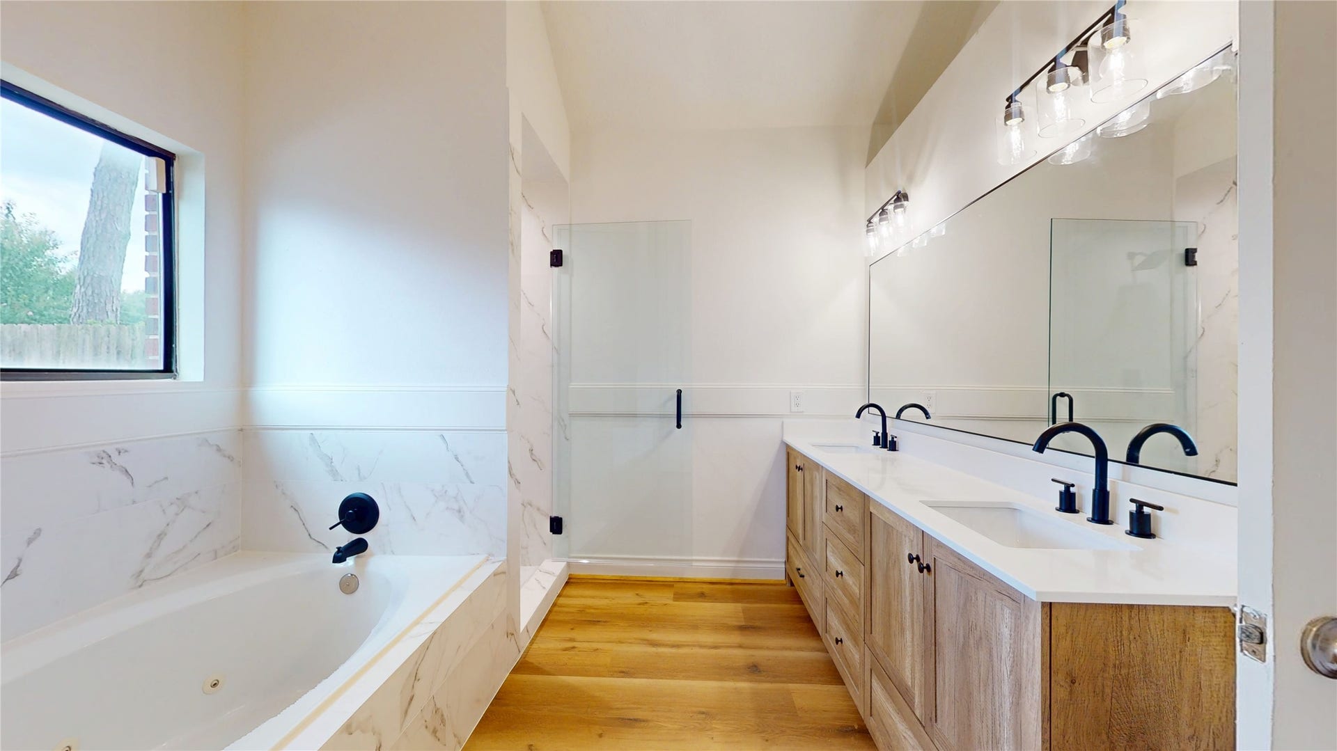 Beautifully remodeled primary bathroom featuring a luxurious jetted tub for relaxing and unwinding.