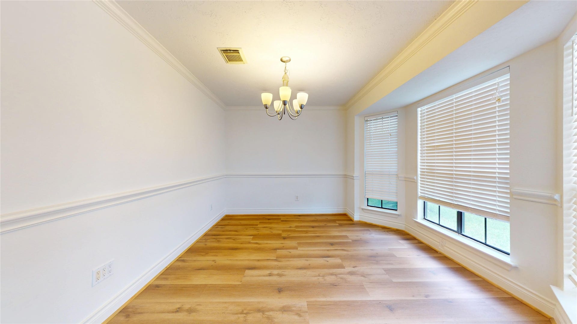 The inviting dining room offers an elegant setting for both intimate dinners and larger gatherings. Abundant natural light creates a bright, welcoming atmosphere, while the spacious layout provides plenty of room for a dining table and furnishings.
