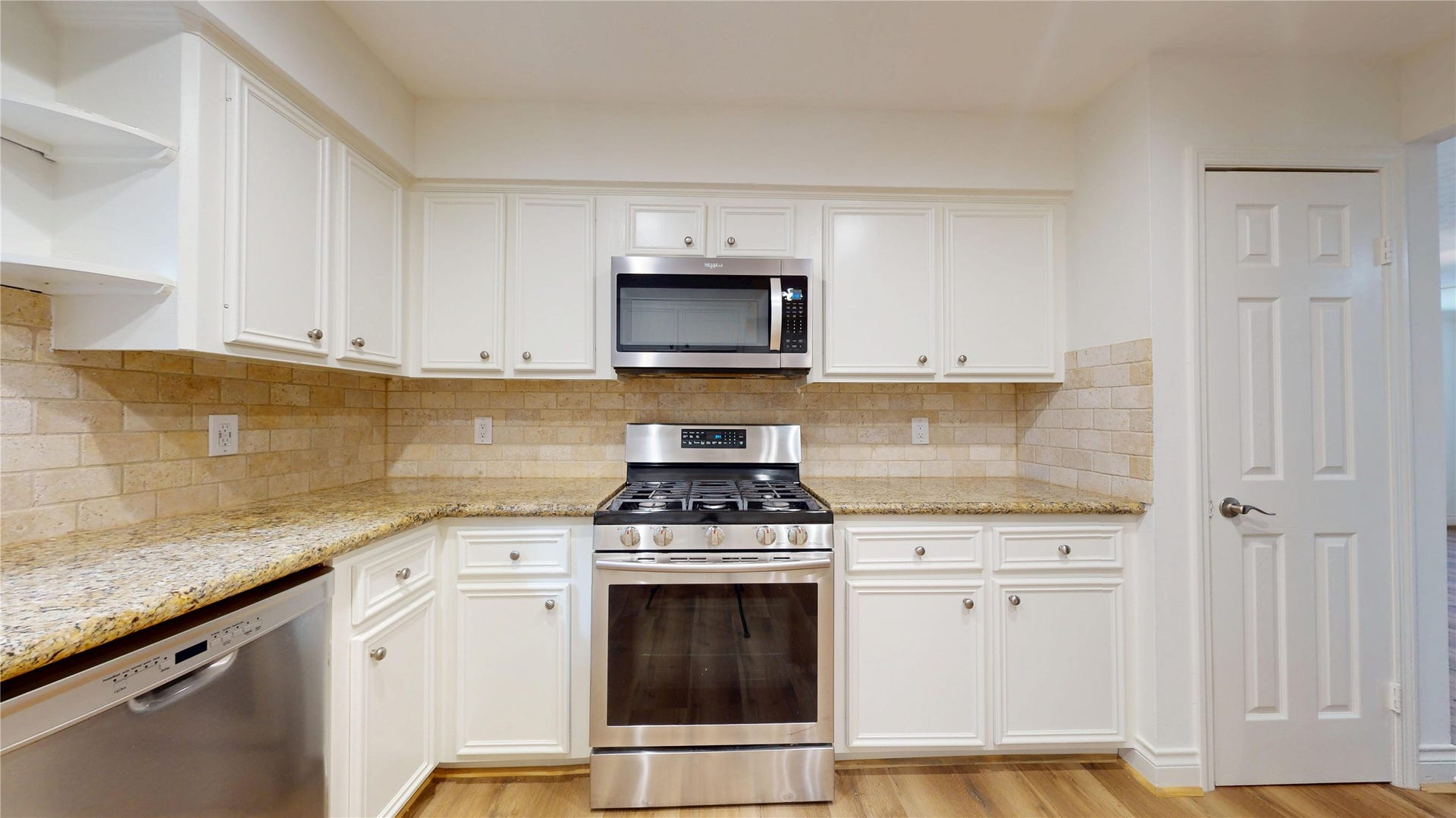 Abundant cabinetry provides plenty of storage, complemented by granite countertops and ample workspace.