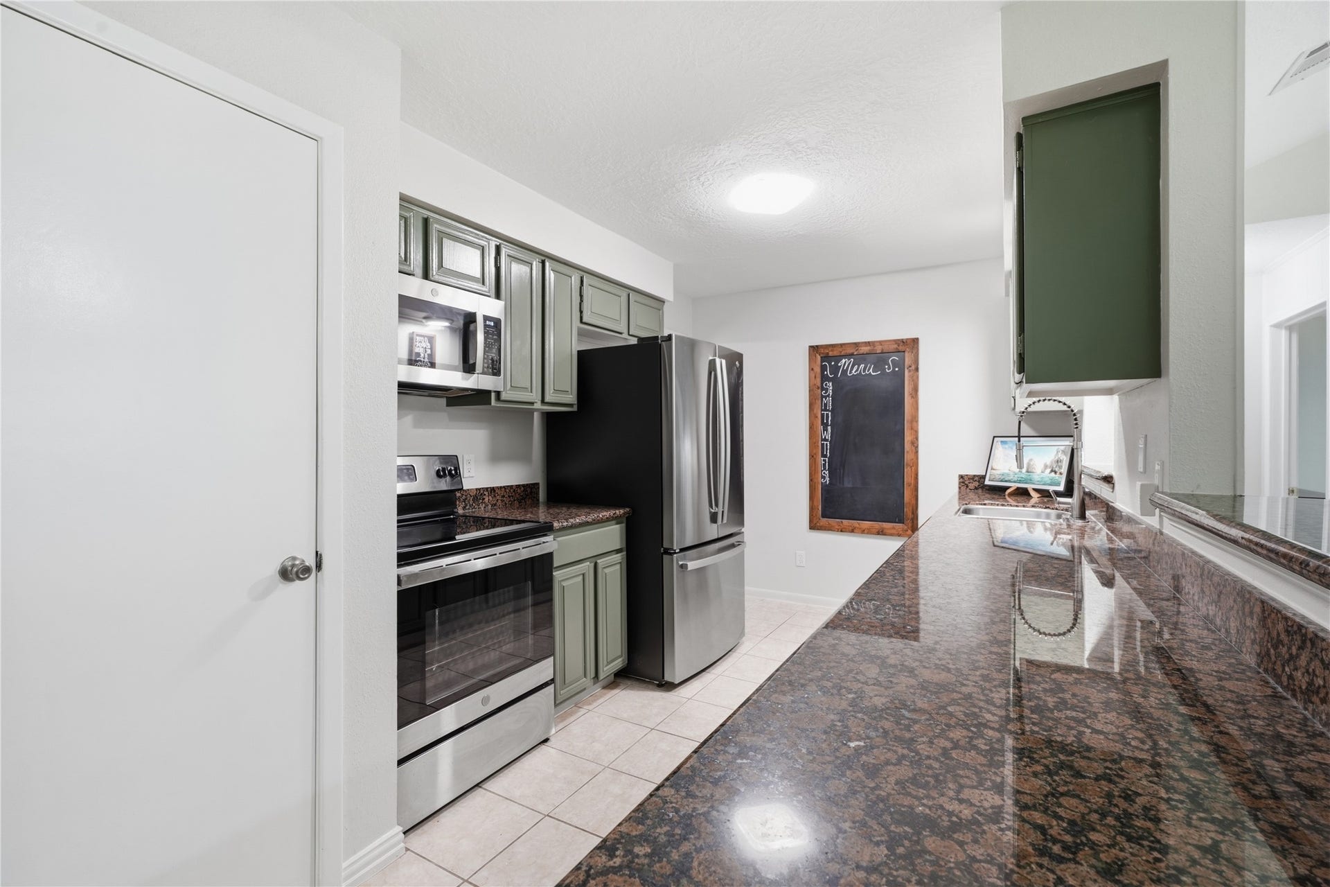 4850 Kentington Drive, Alvin, TX 77511 Functional kitchen layout with abundant storage, expansive work surfaces, and easy access to both the dining room and living room.