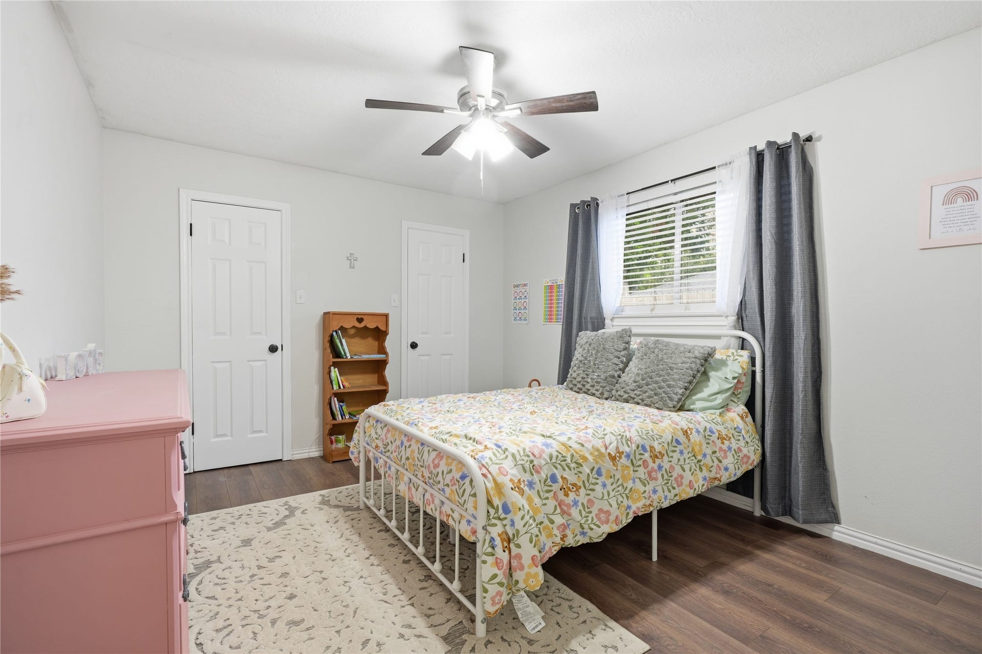 4850 Kentington Drive, Alvin, TX 77511 Comfortable secondary bedroom with wood-look flooring, ceiling fan, large window, and closet for ample storage.