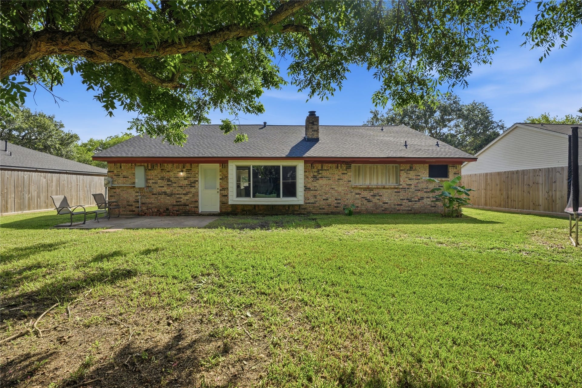 4850 Kentington Drive, Alvin, TX 77511 Large backyard featuring a patio, spacious lawn, and ample space for entertaining or relaxing outdoors.