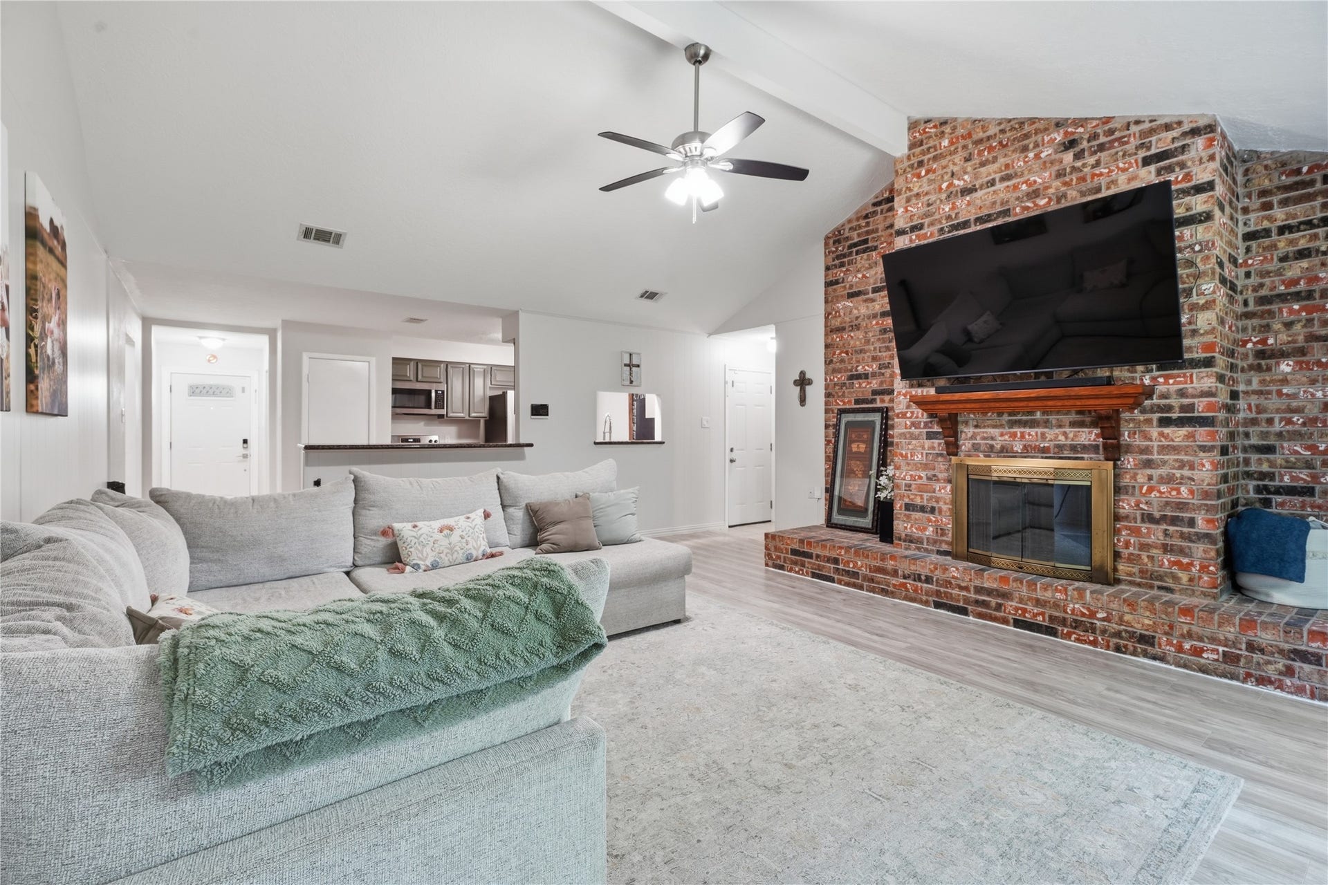 4850 Kentington Drive, Alvin, TX 77511 Inviting living area highlighted by a floor-to-ceiling brick fireplace, vaulted ceiling, and open sightlines to the kitchen and entryway.