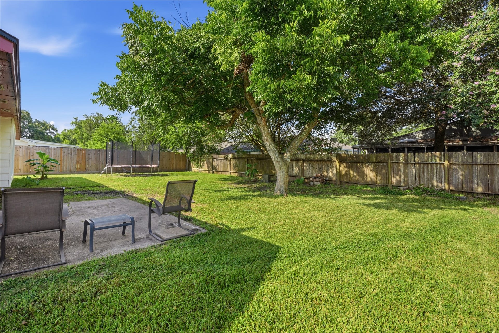 4850 Kentington Drive, Alvin, TX 77511 Private, fully fenced backyard with mature trees, a spacious lawn, and plenty of room for outdoor entertaining or hobbies.