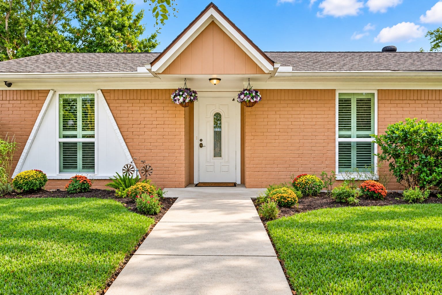 Charming single-story home with manicured landscaping, mature trees, and a welcoming front path leading to a stylish entrance.
