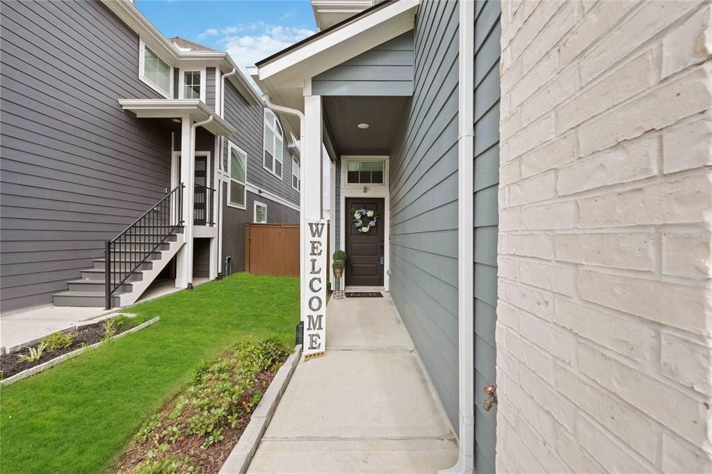 Virtually Staged - Charming entrance with a welcoming Virtually Staged - sign, neat landscaping, and clean pathways leading to a stylish front door with a decorative wreath.
