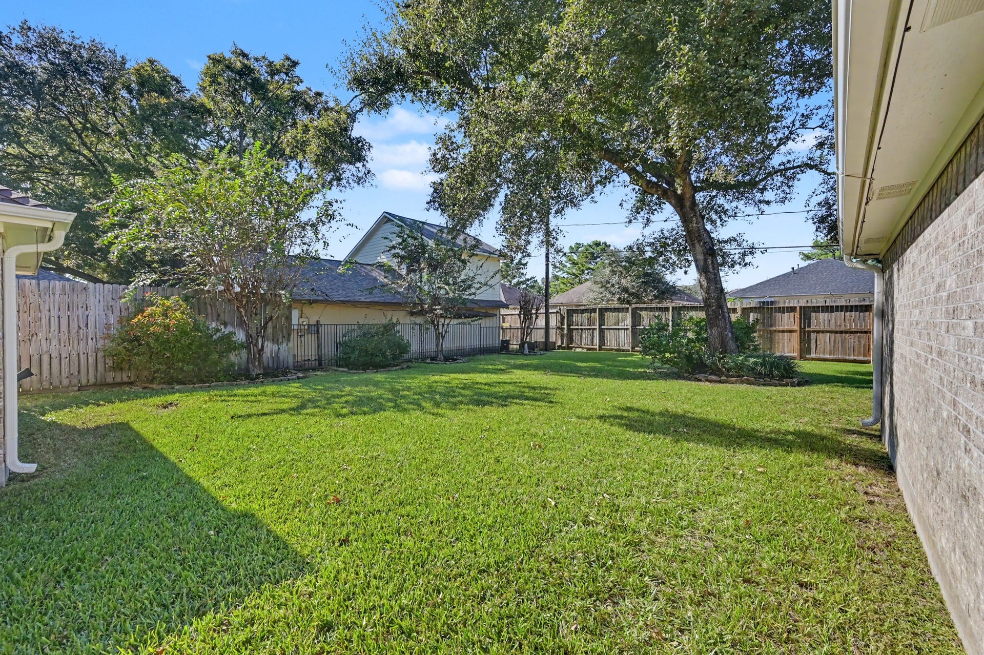 419 Dover Lane, Spring, TX 77373 Another view of the backyard with lush green lawn, perfect for outdoor activities and relaxation.