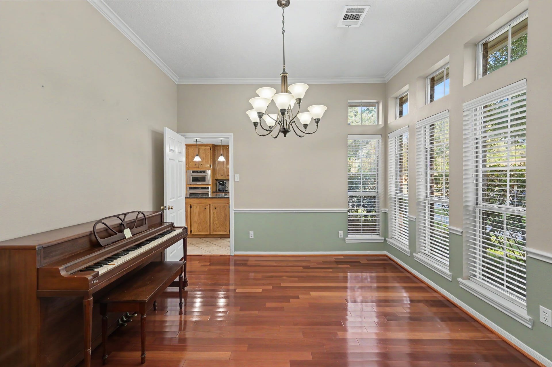 419 Dover Lane, Spring, TX 77373 Bright dining room with elegant chandelier, large windows offering abundant natural light, and rich hardwood floors. Adjacent to the kitchen, perfect for entertaining.
