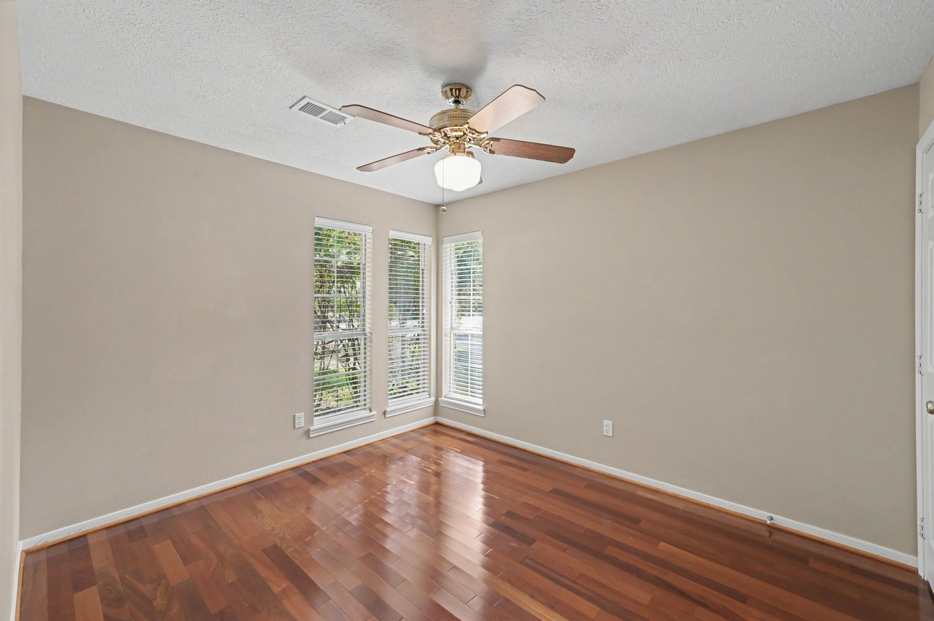 419 Dover Lane, Spring, TX 77373 Bright and inviting bedroom three, featuring hardwood floors, and large windows that bathe the room with plenty of natural light.