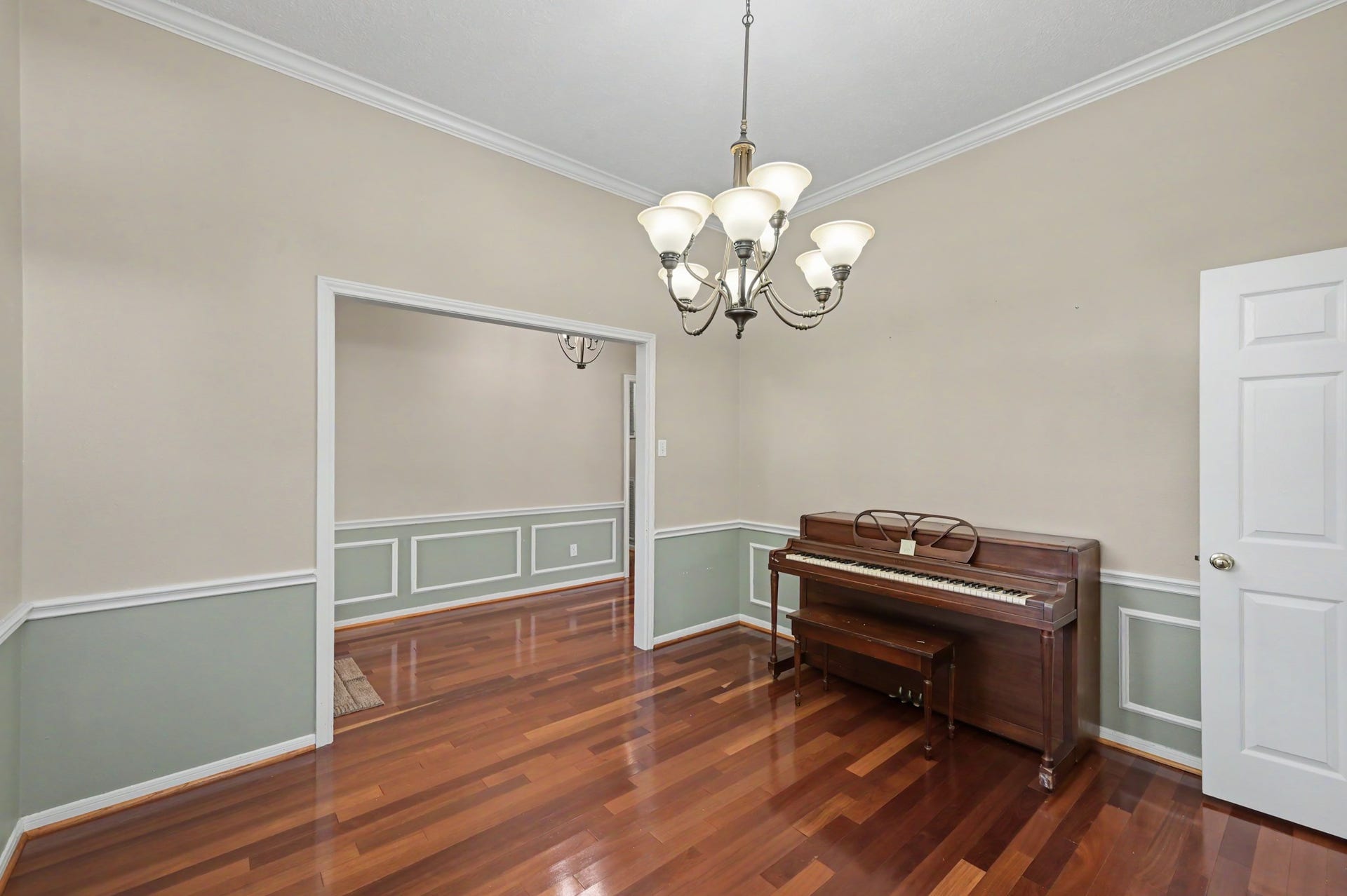 419 Dover Lane, Spring, TX 77373 Elegant dining room with rich hardwood floors, wainscoting, and bathed in natural light.