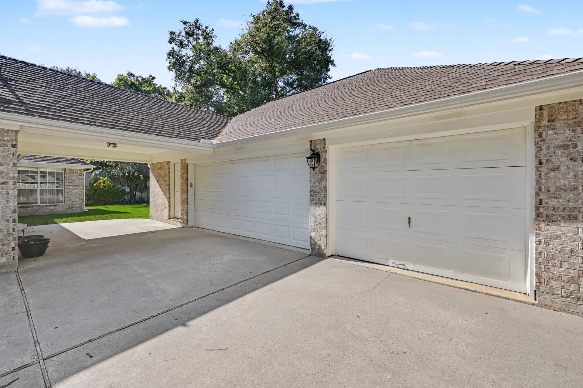 419 Dover Lane, Spring, TX 77373 Spacious driveway leading to a 3-car garage, complemented by a charming covered entryway from the home.