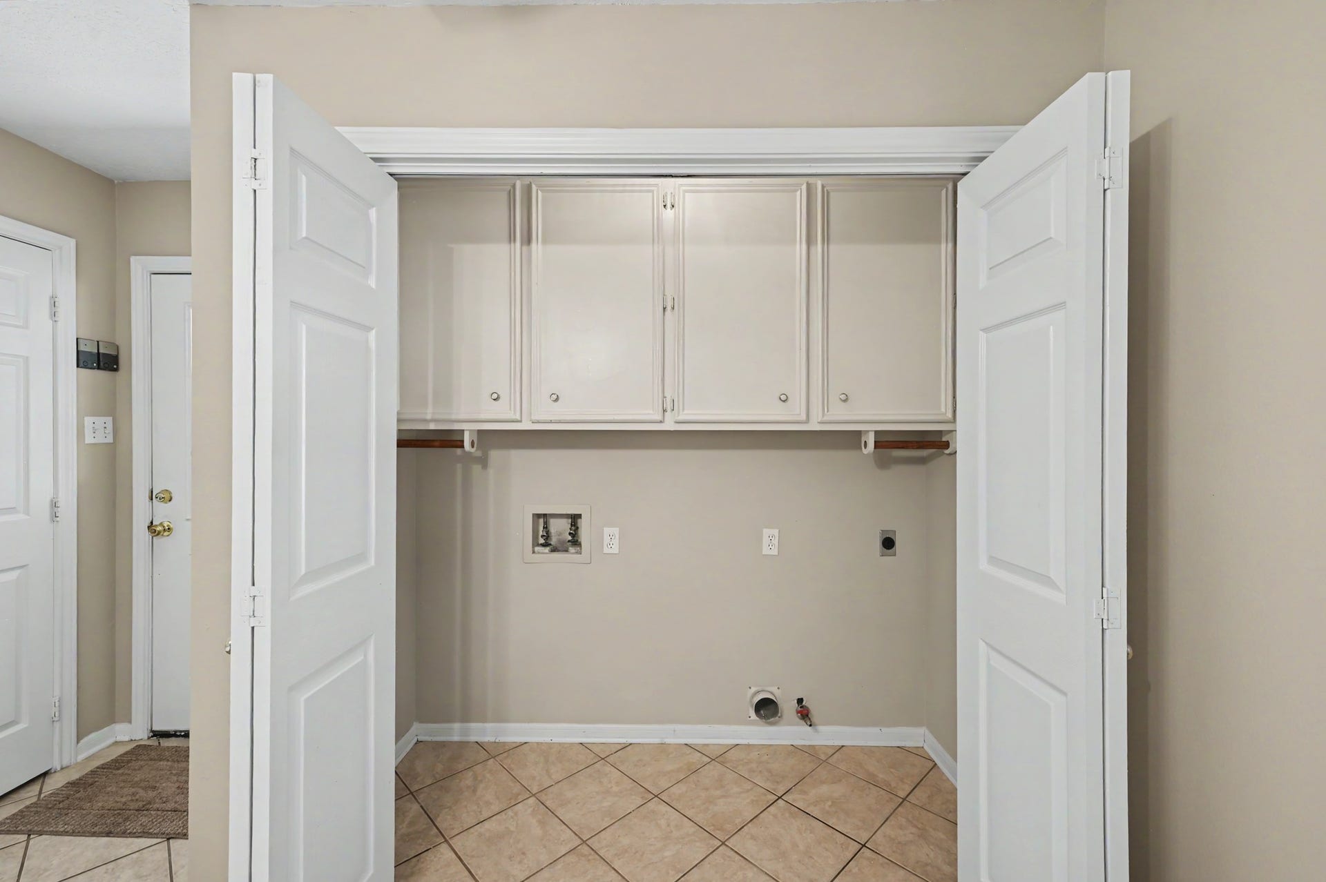 419 Dover Lane, Spring, TX 77373 Convenient laundry space with built-in cabinets and tile flooring, ready for your washer and dryer setup.